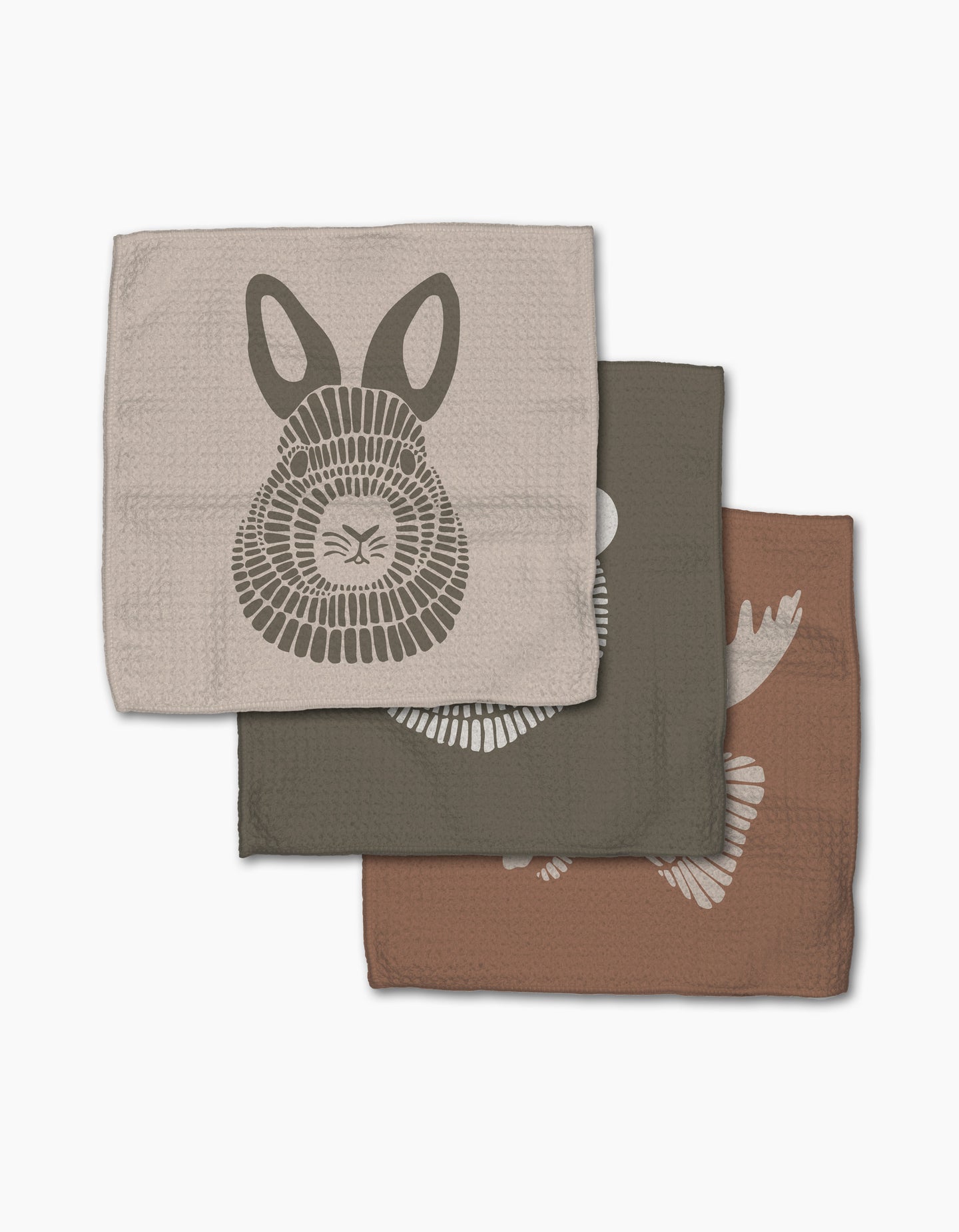 Rosa Kichline’s Forest Animals set includes three folded super-absorbent dishtowels: beige with a bunny face, dark gray with a fish, and brown featuring part of a bird illustration.