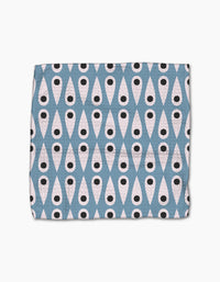 The Forest Findings dishcloth set by Anette Heiberg is made from recycled materials and features a bold geometric pattern of white ovals with black dots on a blue diamond background for an eye-catching look.