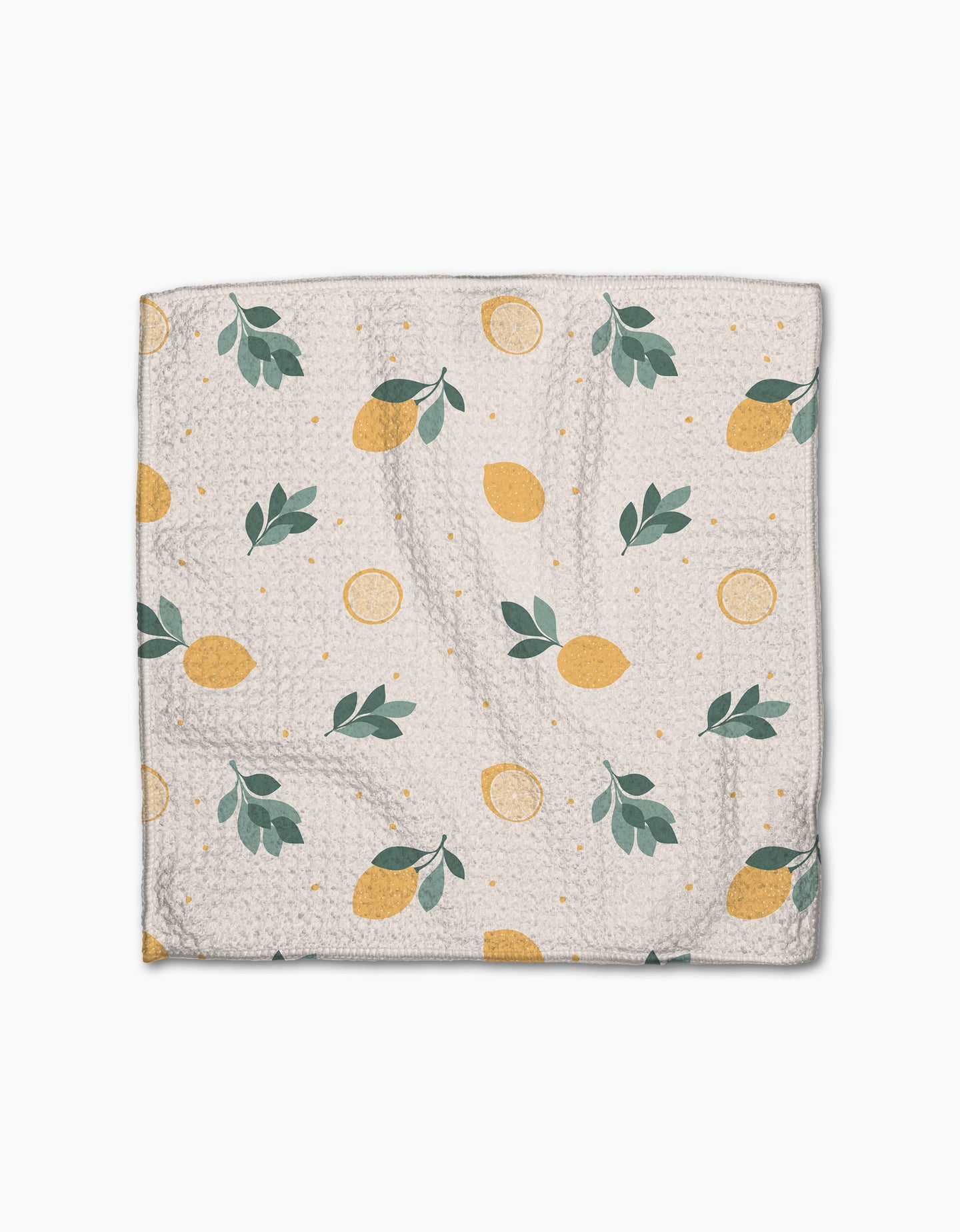 The Sara Mari “Freshly Picked” dishcloth features Geoweave fabric and a white background with yellow lemons, lemon slices, green leaves, and small yellow dots scattered across the surface.