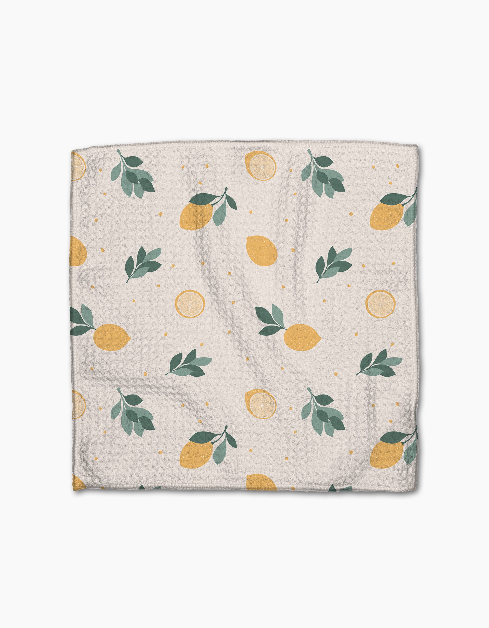 The Sara Mari “Freshly Picked” dishcloth features Geoweave fabric and a white background with yellow lemons, lemon slices, green leaves, and small yellow dots scattered across the surface.