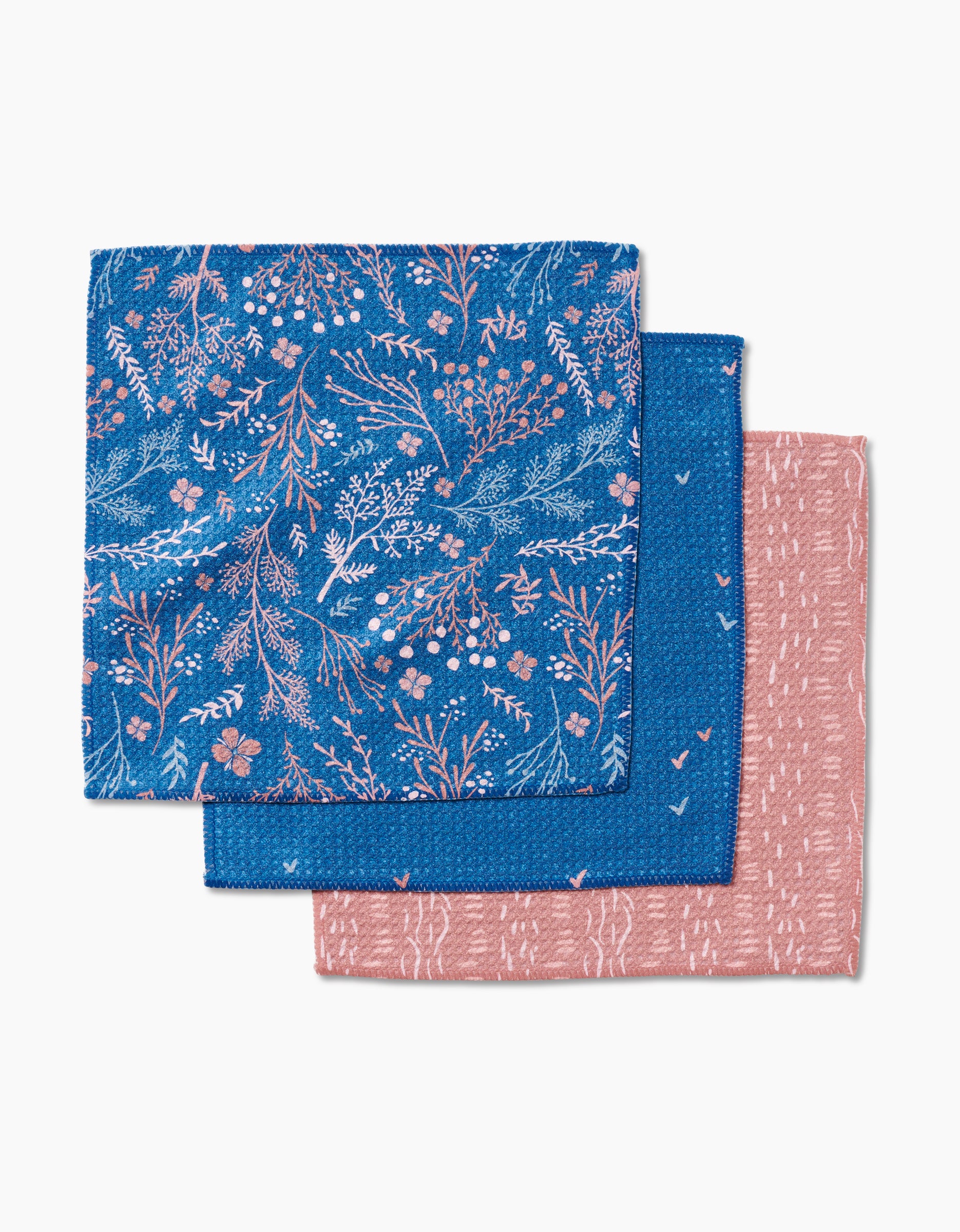 Three reusable Garden Seeds dishcloths by Danelys Sidron: blue floral, solid blue with pink dots, and pink with abstract white—all made with durable Geoweave fabric.