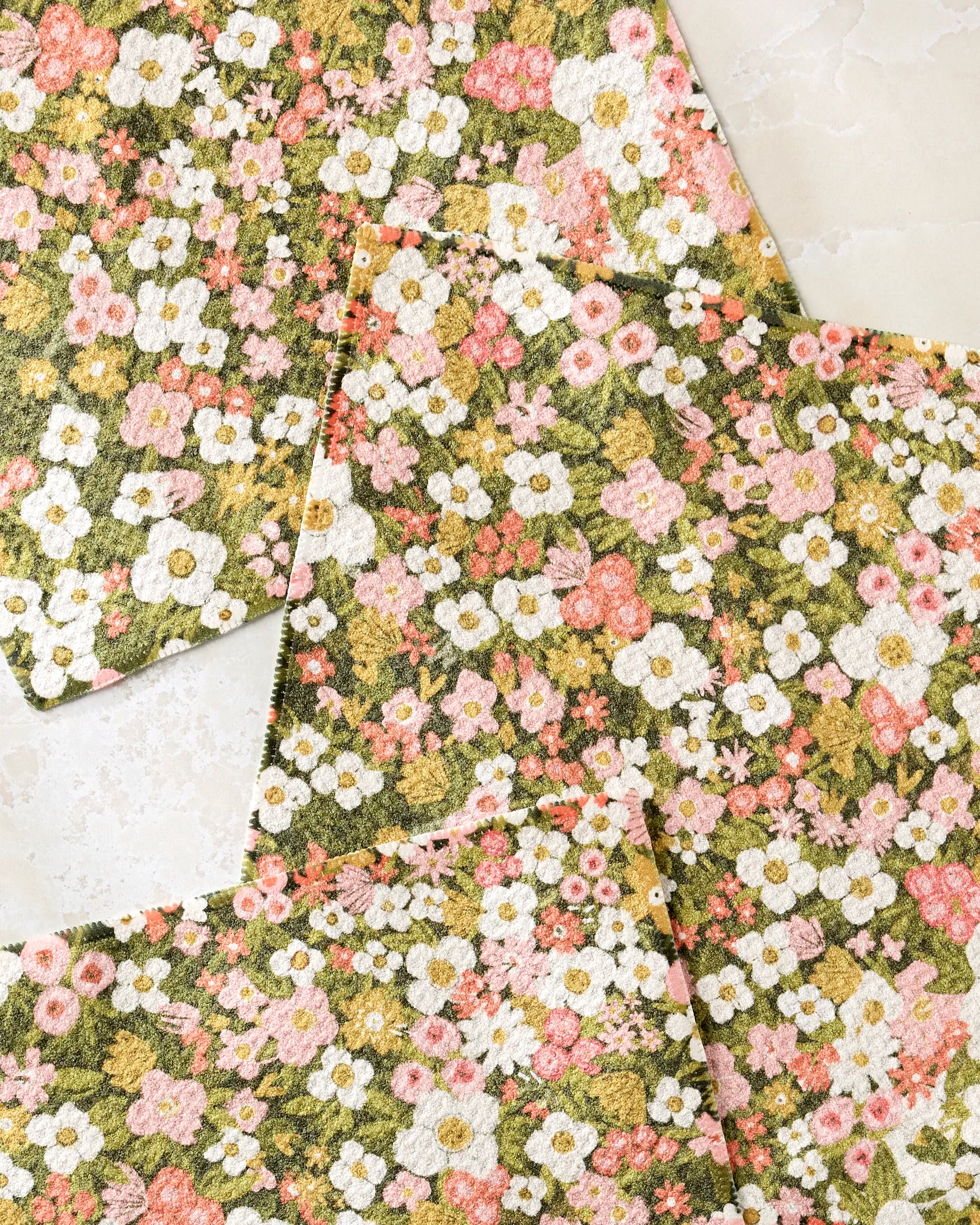 Four super-absorbent Gilded Garden dishtowels by Lisa Nelson feature a dense floral pattern of white, pink, and yellow blooms overlapping on a light marble surface.