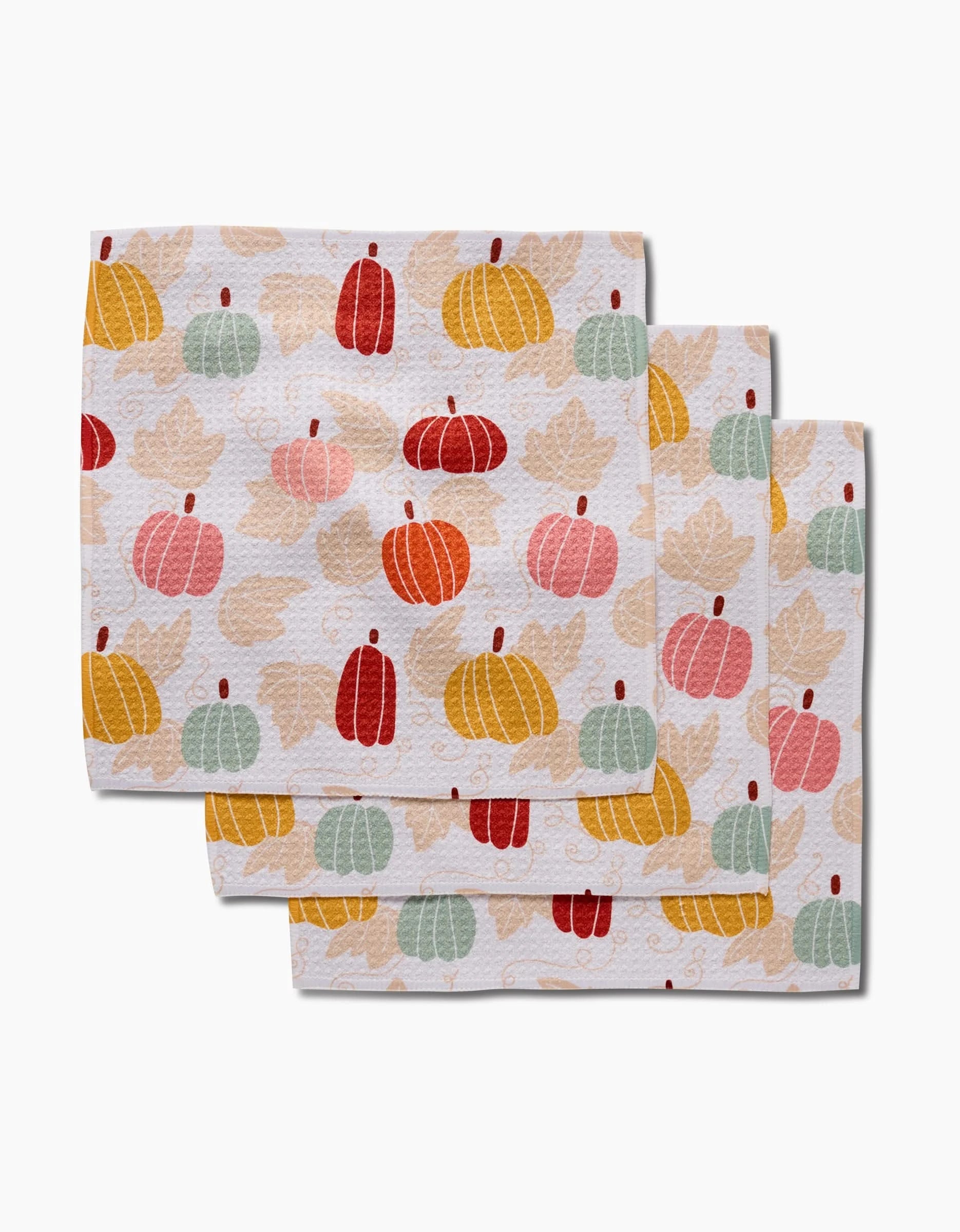 The Sara Mari Golden Fall Field set includes three super-absorbent dishtowels, each showcasing pumpkins and leaves in autumn colors—orange, red, yellow, pink, and green—on a white background.