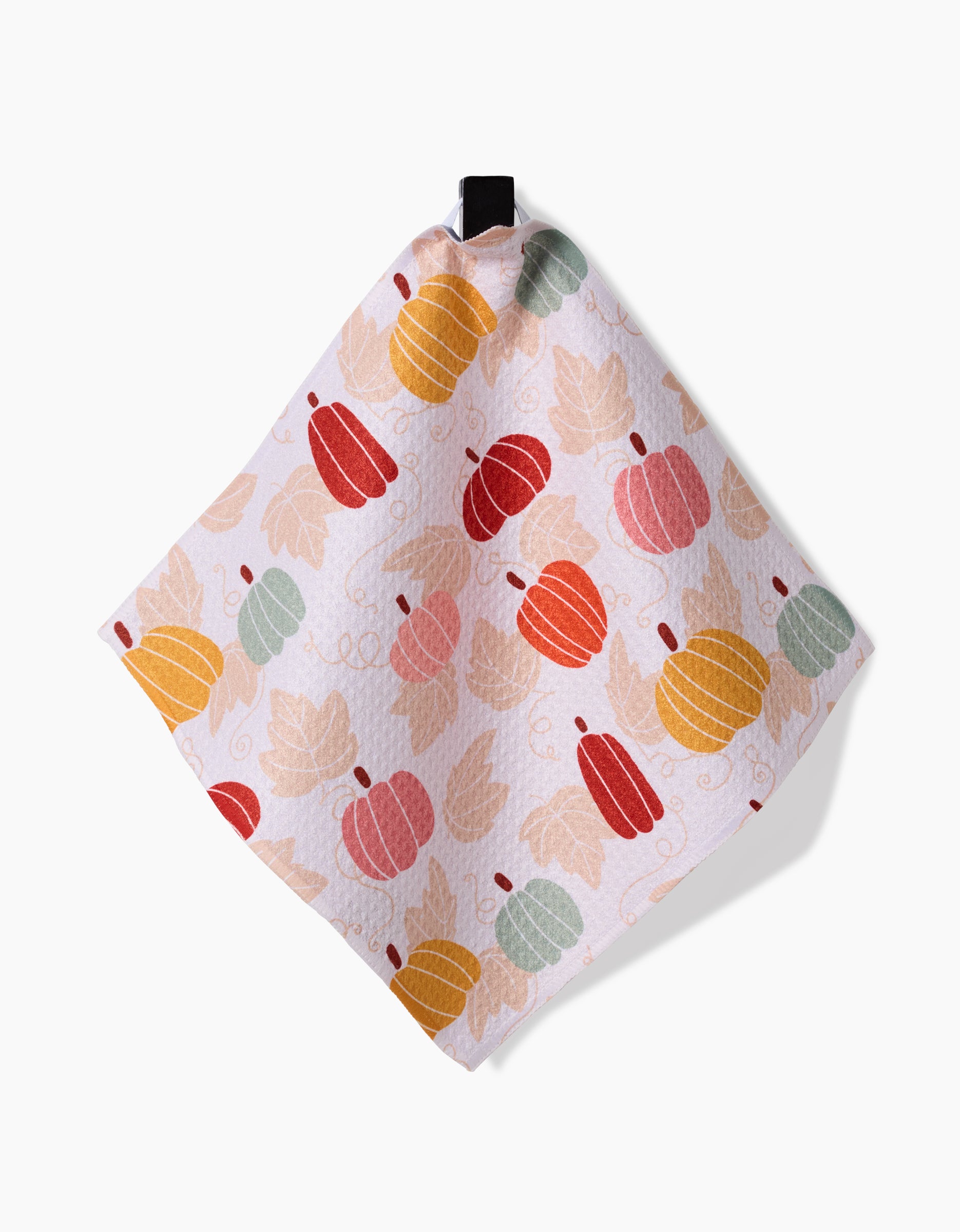 The Sara Mari Golden Fall Field towel is a square white piece made from recycled materials, featuring orange, yellow, red, and green pumpkins with beige leaves and a black hanging loop on a white background.