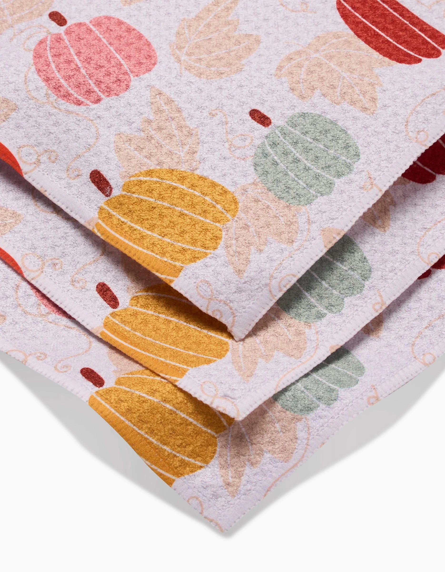 The Sara Mari Golden Fall Field dishtowels feature a fall-themed pumpkin and leaf pattern in vibrant colors on white. Made from recycled materials, these super-absorbent towels offer eco-friendly style for your home.
