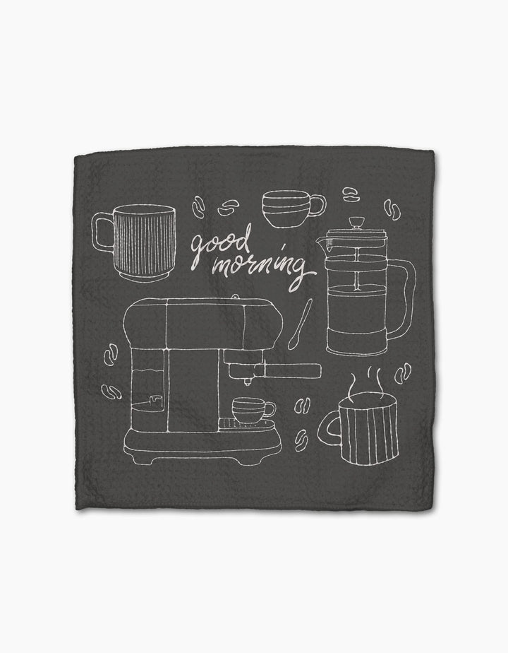 The Rosa Kichline Good Morning Coffee napkin is dark, made from recycled materials, with white line art of coffee mugs, a French press, espresso machine, beans, and good morning in cursive at the center.