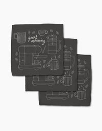 The Rosa Kichline Good Morning Coffee set includes three black recycled cloth napkins with minimalist white line art of coffee cups, a French press, beans, and good morning cursive in a repeating pattern.