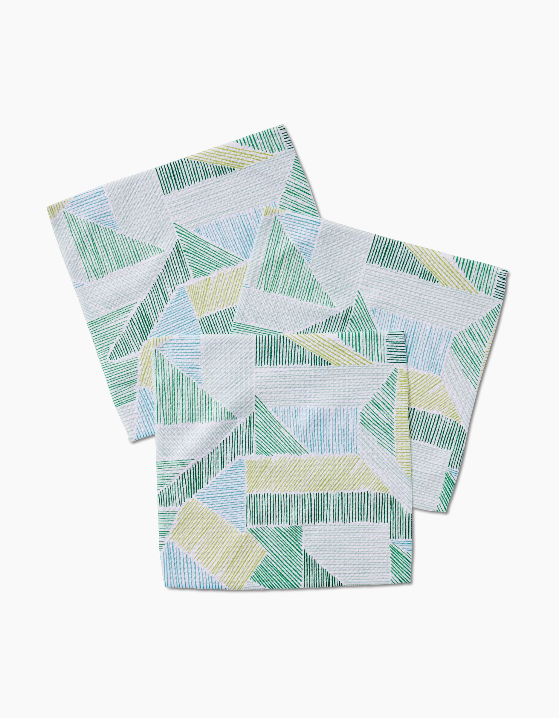 Three Green Kites fabric napkins by GEOMETRY, made from recycled materials, showcase a geometric pattern of overlapping blue, green, and yellow lines forming triangles and rectangles on a white background.