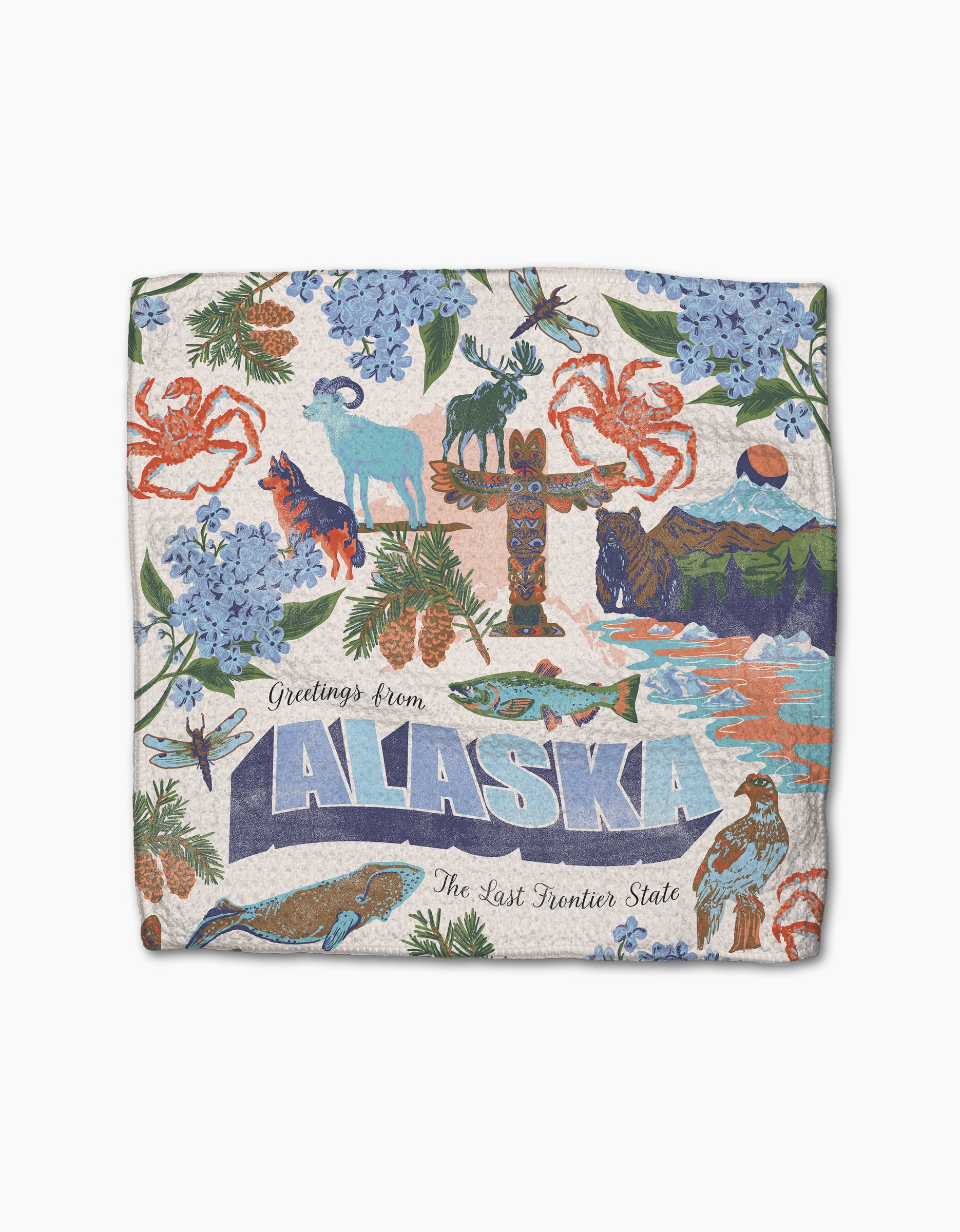 Geometry’s “Greetings From Alaska” dishcloths feature a vibrant design of Alaskan wildlife, flowers, mountains, crabs, and a totem pole with “Greetings from ALASKA, The Last Frontier State” on recycled fabric.