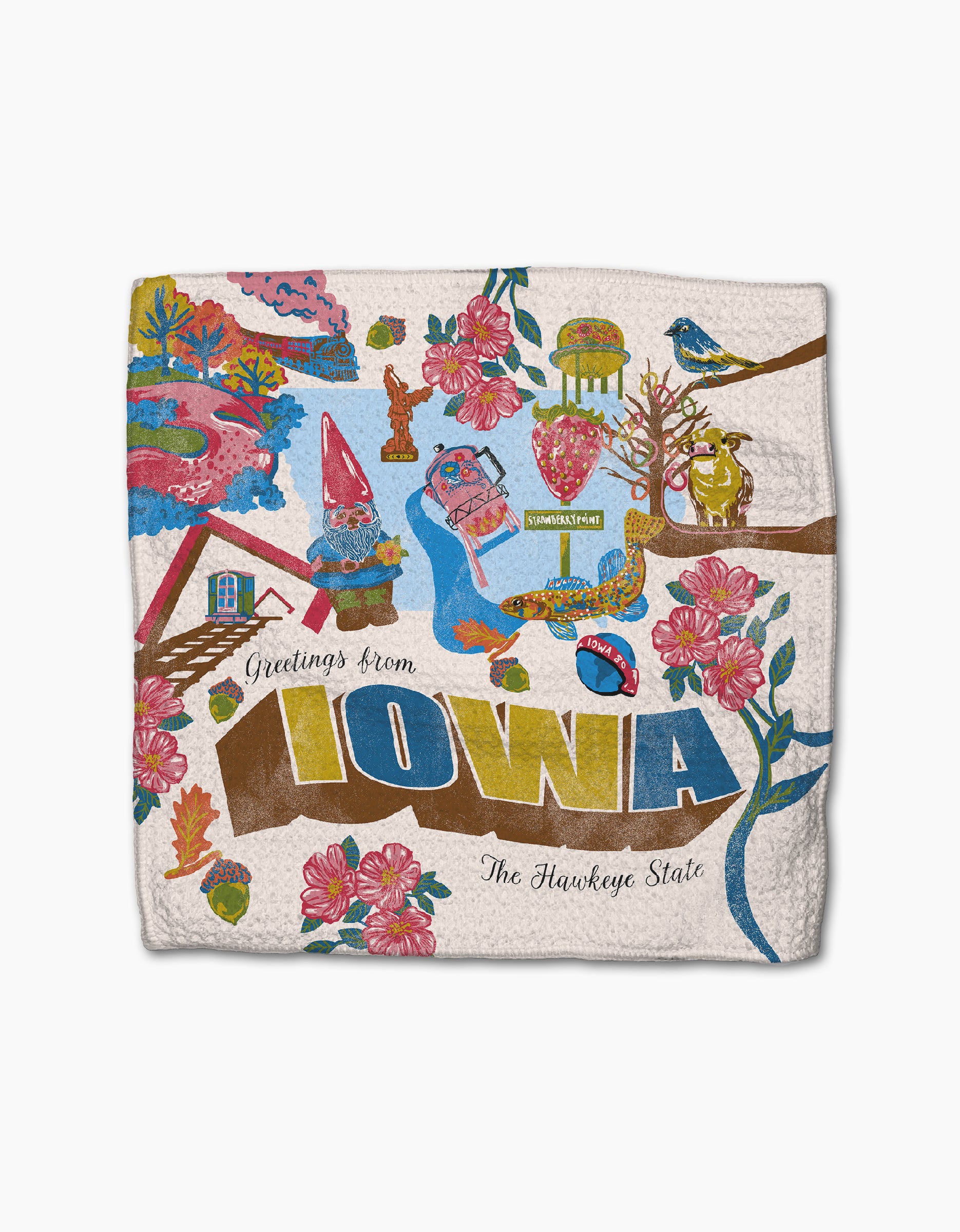 Geometry’s “Greetings From Iowa” decorative towel, made from recycled materials, features colorful illustrations of Iowa landmarks, flowers, a gnome, a bluebird, and bold “Greetings from IOWA, The Hawkeye State” text.