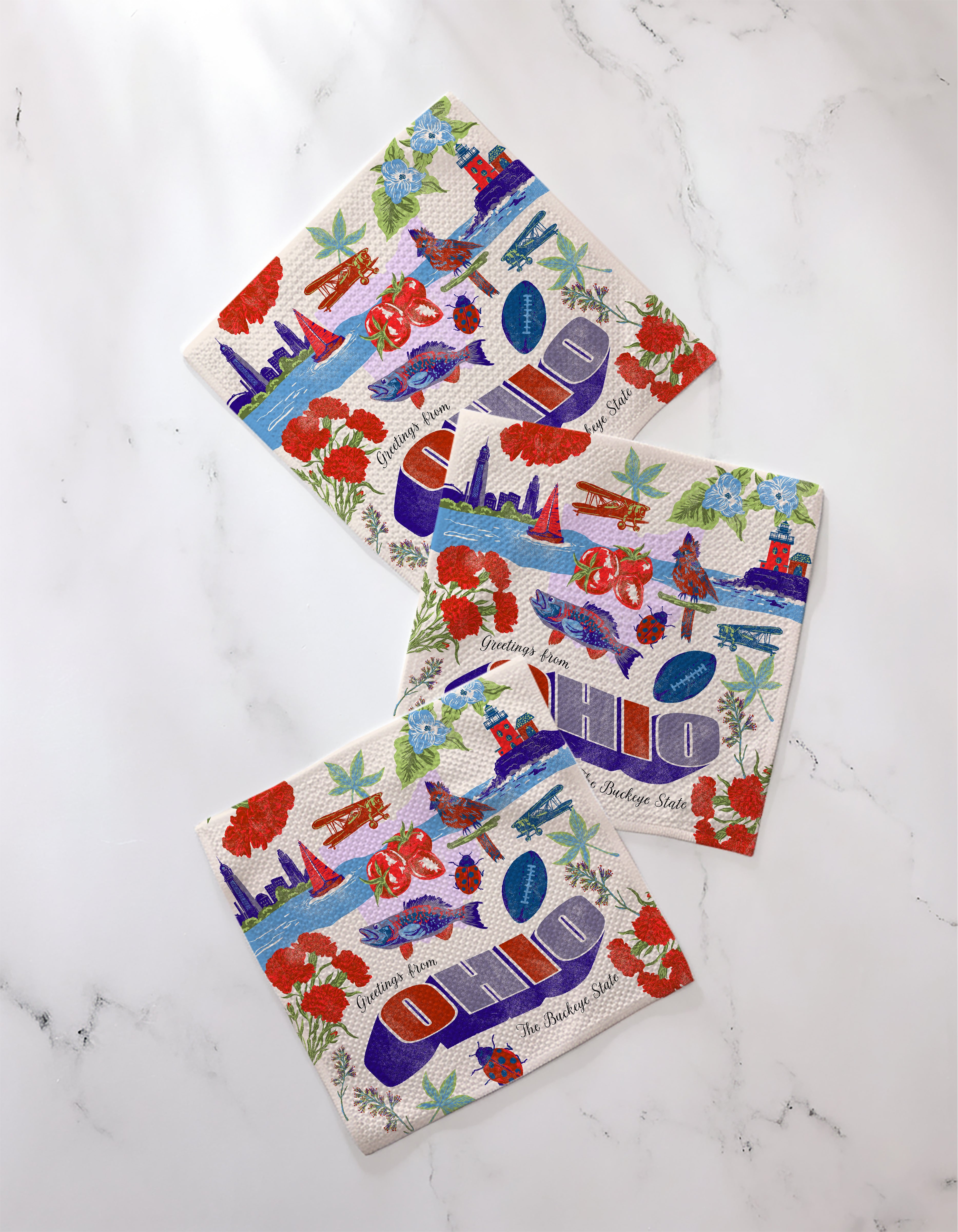 The Geometry "Greetings From Ohio" napkin set features a variety of designs, making it ideal for any occasion and a perfect match with absorbent dishcloths.