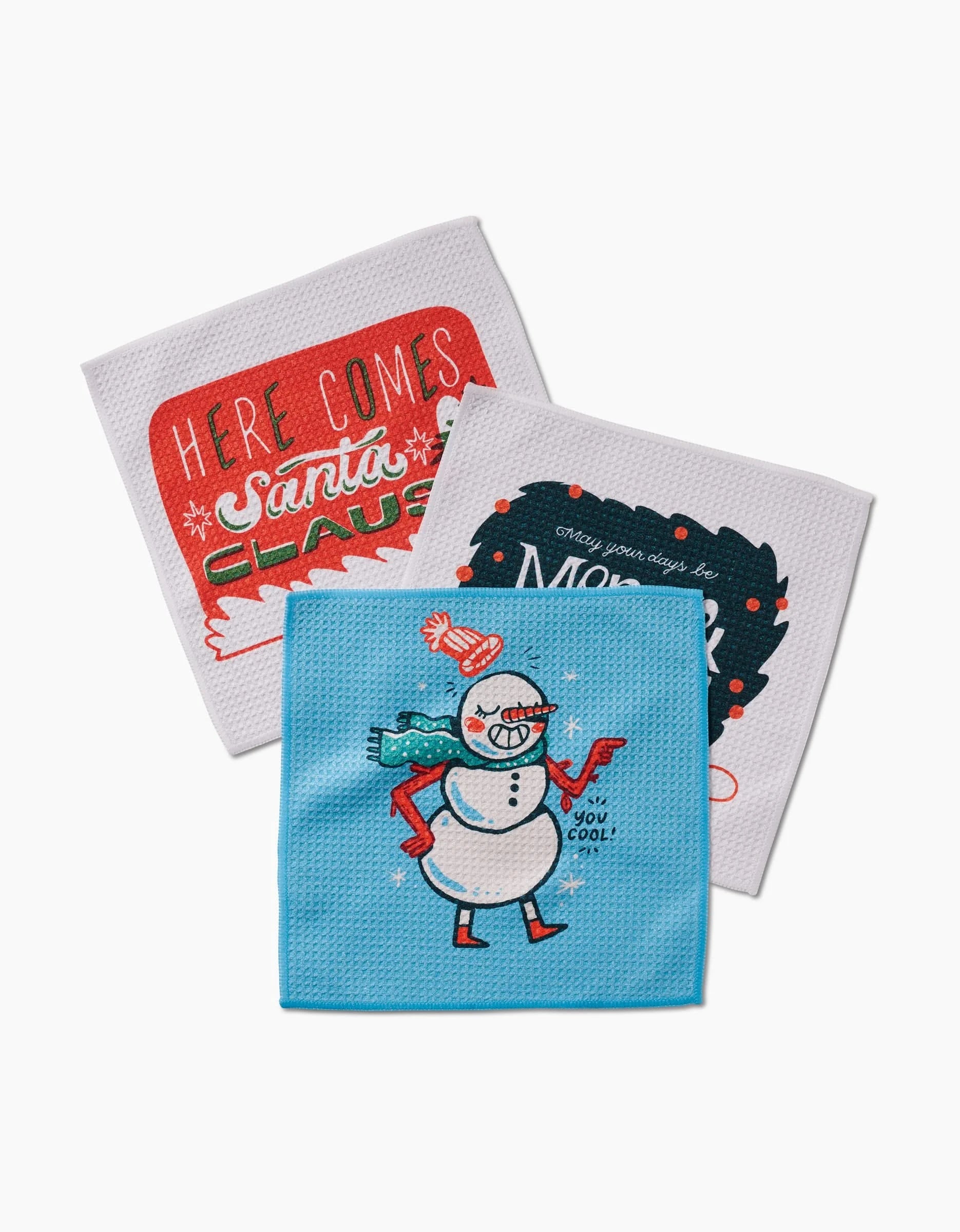 The Carly Berry Here Comes Santa Claus set includes three durable Geoweave holiday dishcloths: one with Here Comes Santa Claus in red, another with Merry Christmas in white and red, and a third with a snowman on blue.