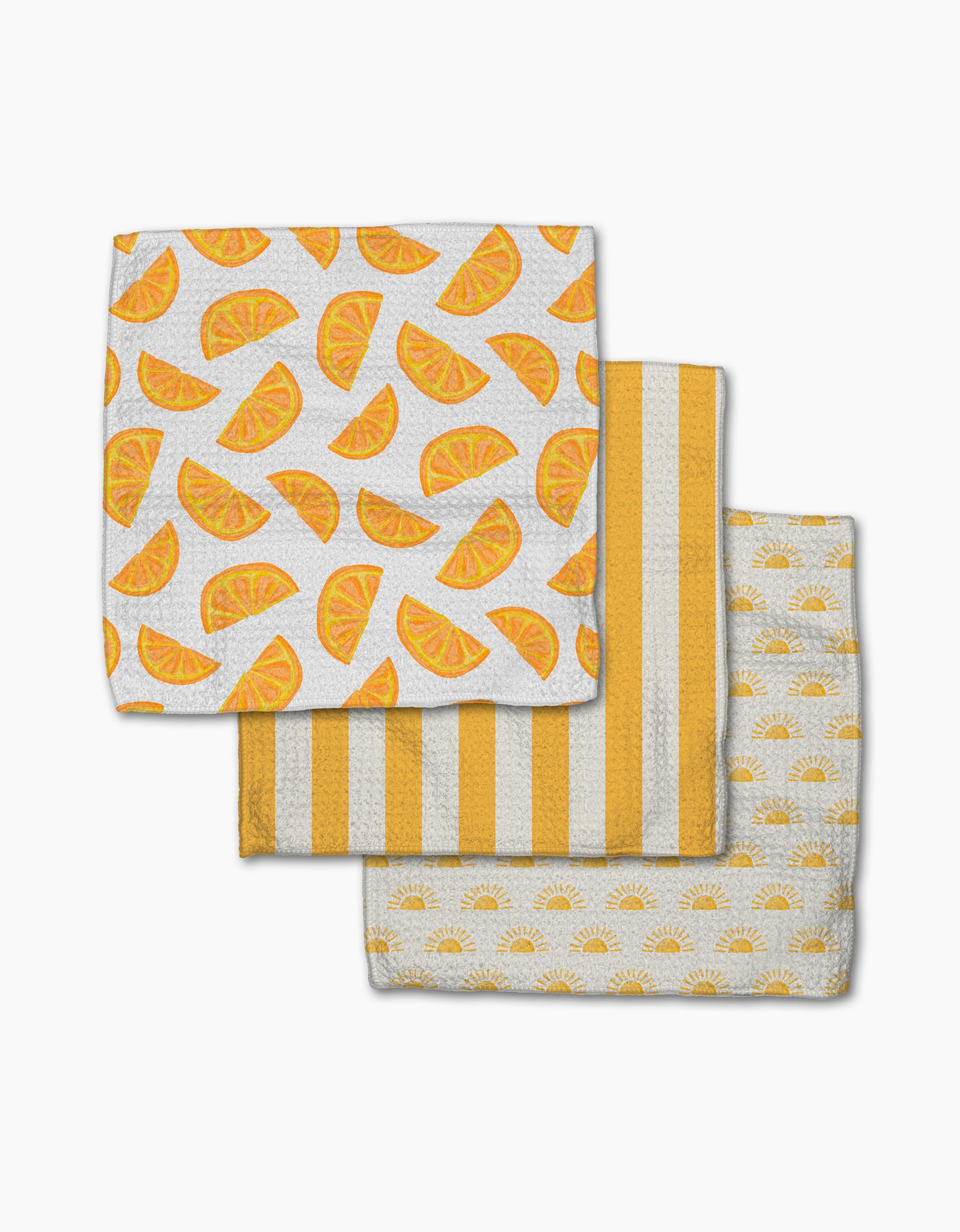 The “Here Comes The Sun” set from Aubrey Fairchild features three Geoweave kitchen towels: orange slice print, yellow and white stripes, and small yellow suns, all beautifully arranged on a white background.