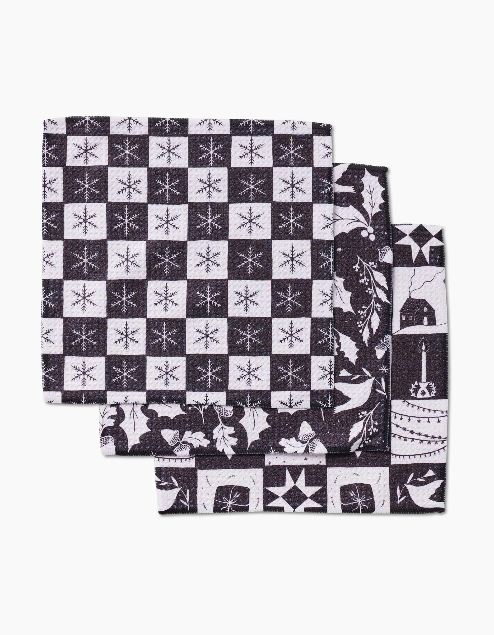 The Holiday Love napkin set by Elana Gabrielle includes three black and white patchwork napkins with snowflakes, stars, and festive patterns, crafted from recycled materials for sustainable holiday style.