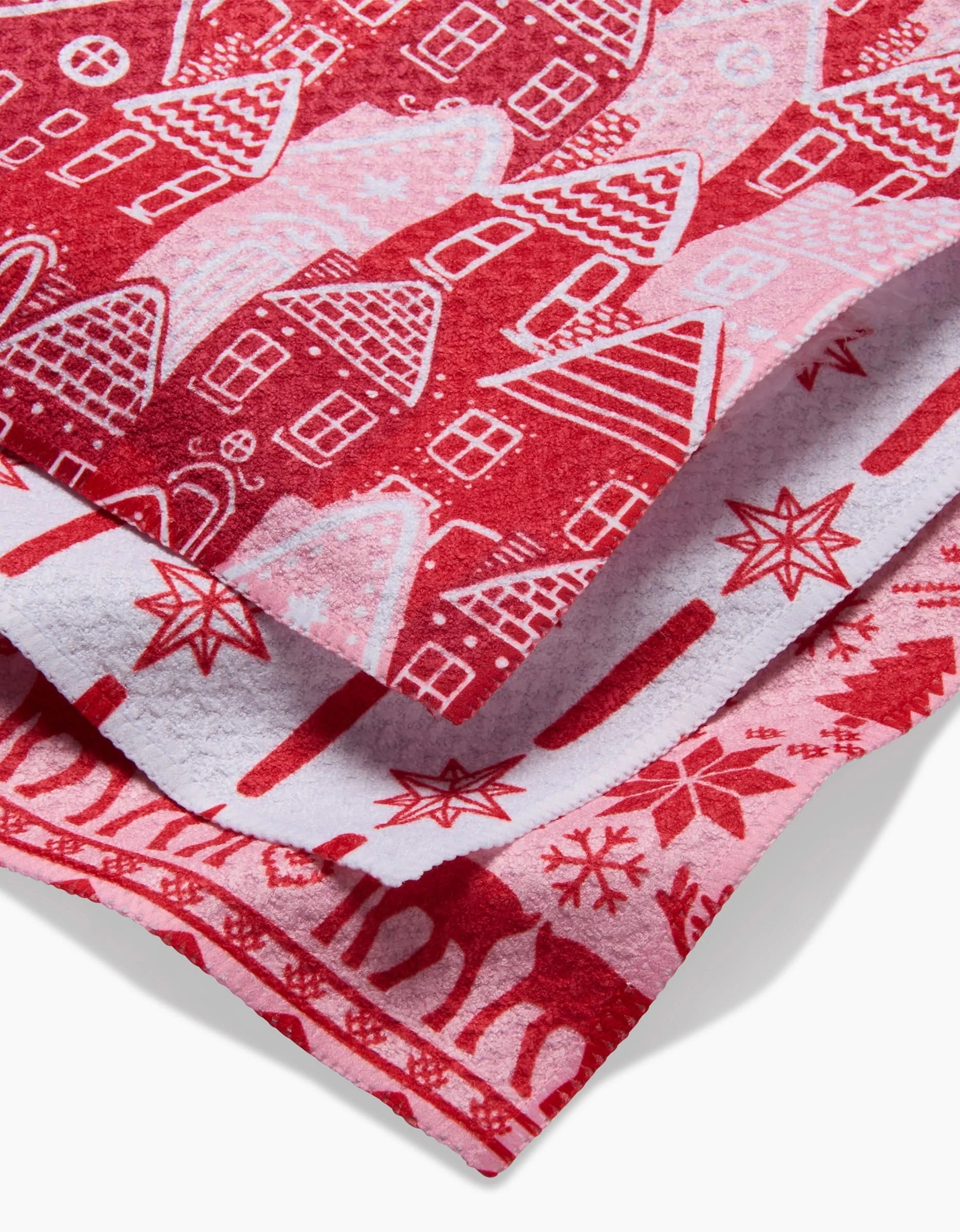 A close-up of the Holidays kitchen towel by Hufton Studio, made from Geoweave fabric with red and white festive patterns. This absorbent towel is perfect for winter and Christmas celebrations.