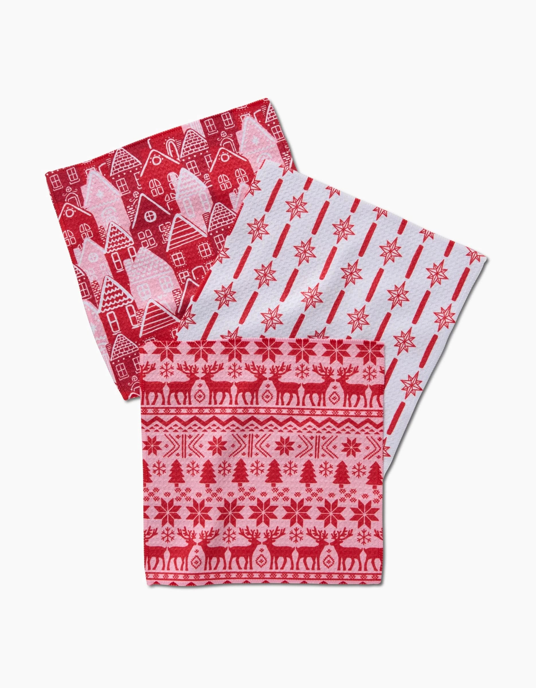Three folded Hufton Studio “Holidays” kitchen towels—one with houses and snowmen, one with red snowflakes, and one with reindeer and snowflakes—made from super-absorbent Geoweave fabric on a white background.