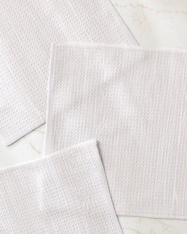 Three "Houston Wood" napkins by Kailee Wright are arranged on a white marble surface, overlapping slightly and positioned at varied angles.