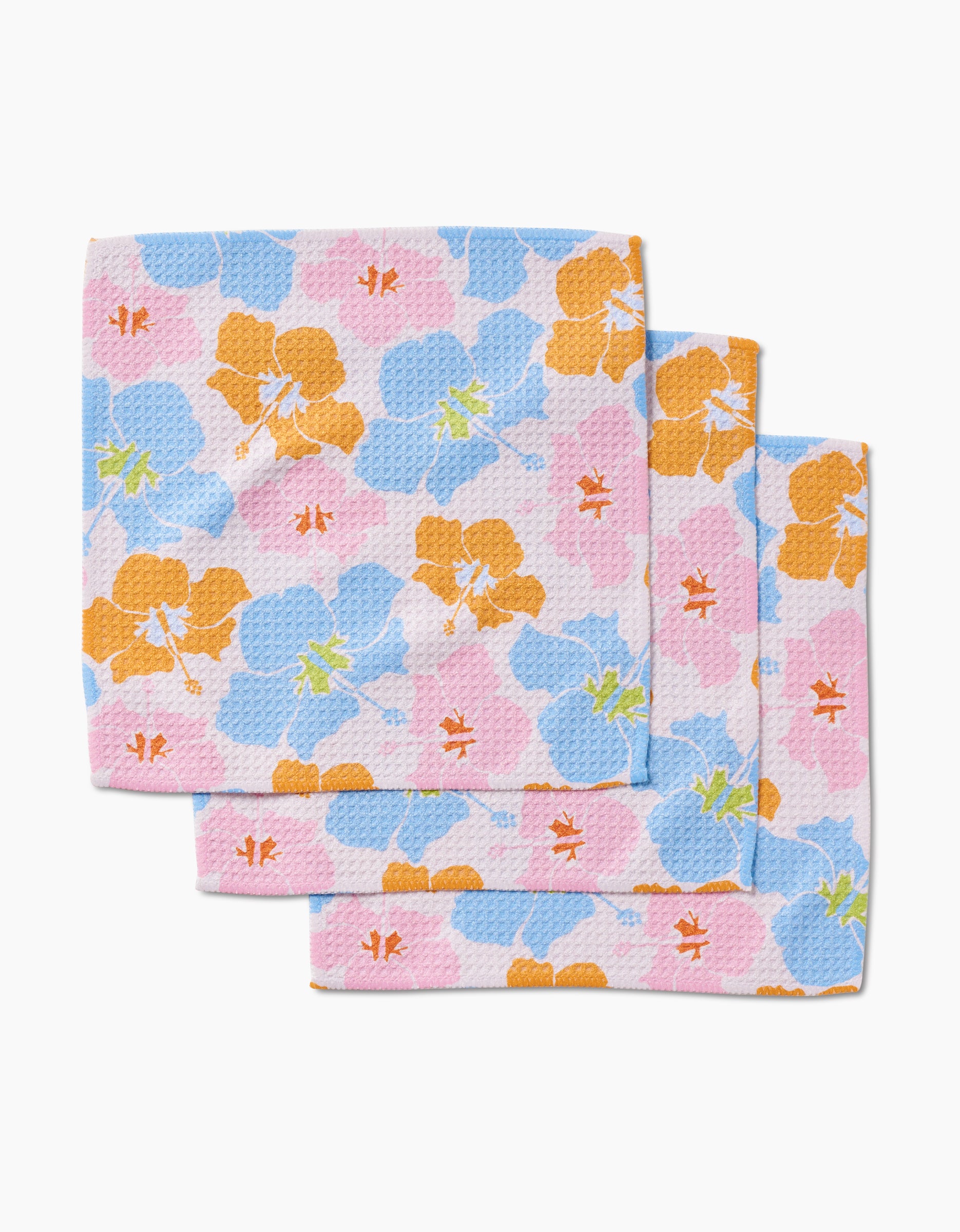 Three GEOMETRY Hula Hues reusable dishcloths with a blue, pink, and orange floral pattern and red dragonflies are stacked slightly overlapping on a white background.