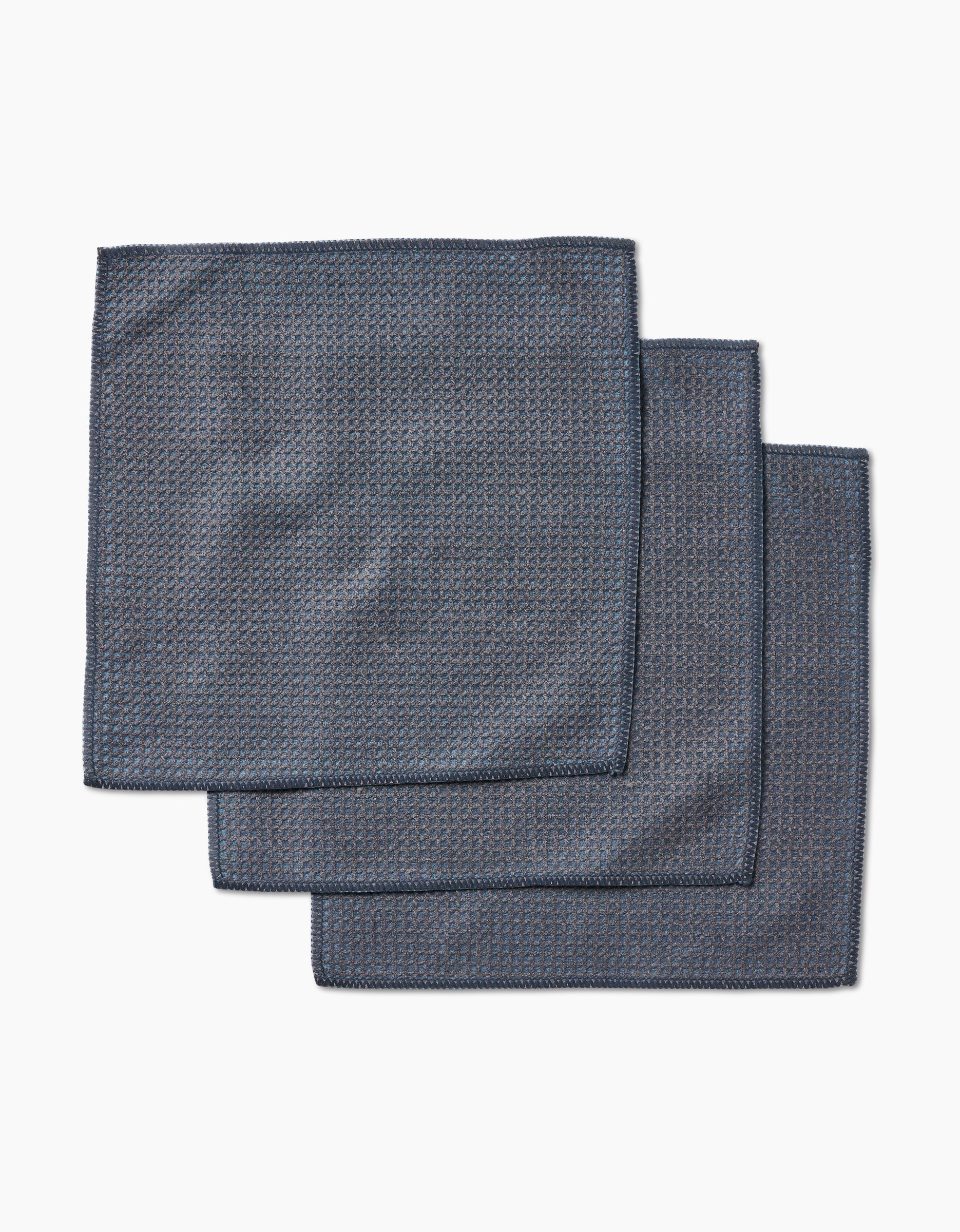 Three neatly stacked hunter green cloth napkins by Kailee Wright, crafted from super-absorbent Geoweave fabric, rest on a white background.