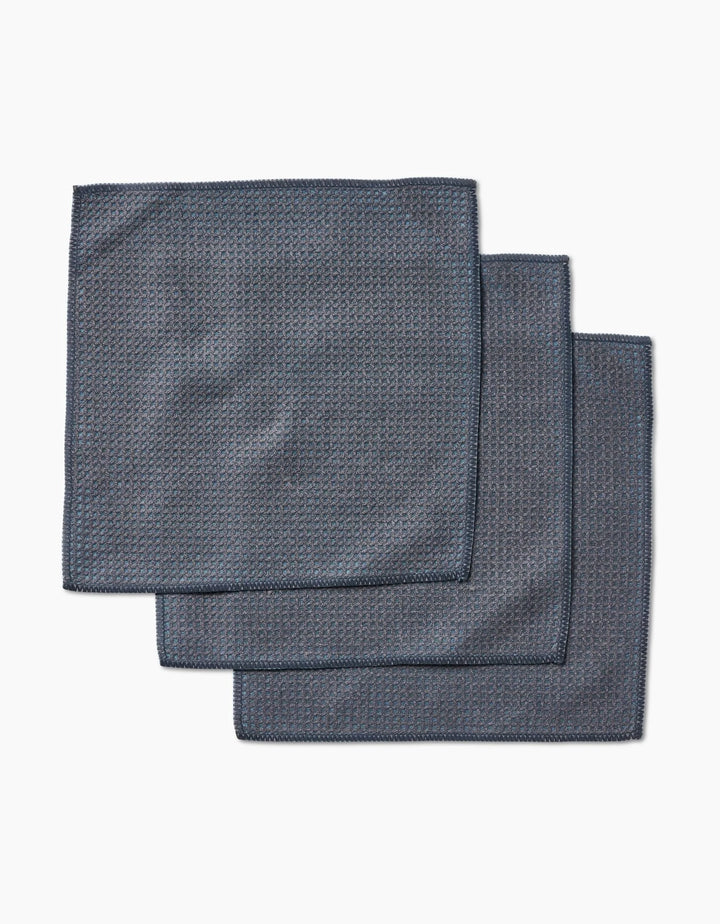 Three neatly stacked hunter green cloth napkins by Kailee Wright, crafted from super-absorbent Geoweave fabric, rest on a white background.