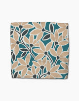 The Janine dishcloth by Amy MacCready features a botanical print with beige and teal leaves and dark stems on textured Geoweave fabric.