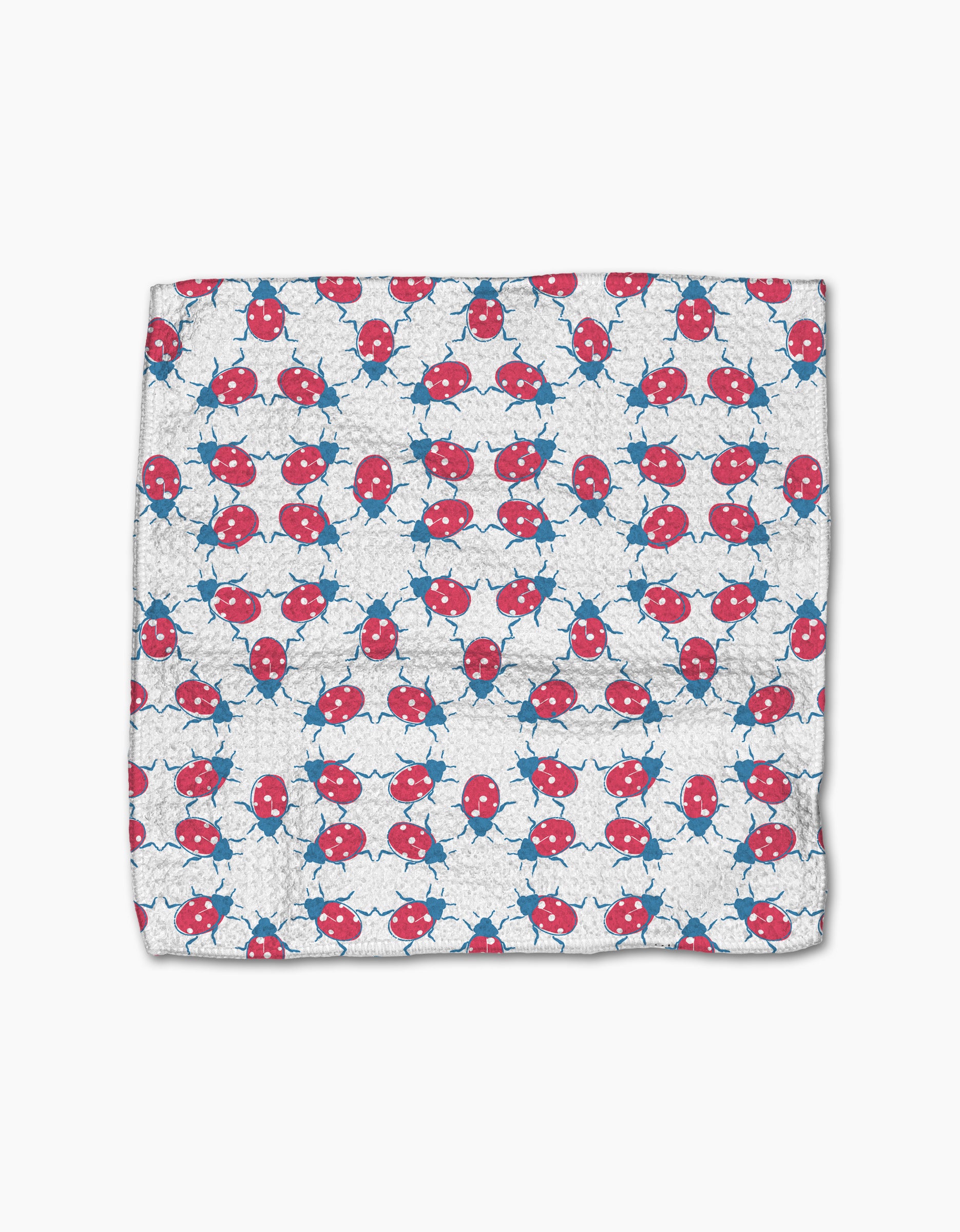 The Ladybug Dance dishcloth by Second Nature Studio features a white Geoweave fabric with rows of playful red and blue ladybugs, crafted from recycled materials for an eco-friendly touch.
