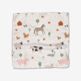 The Coit Creative Light Farm Animals Geoweave dishcloth showcases horses, cows, pigs, sheep, chickens, barns, trees, flowers, and ponds in soft pastels. Made from recycled materials for an eco-friendly touch.