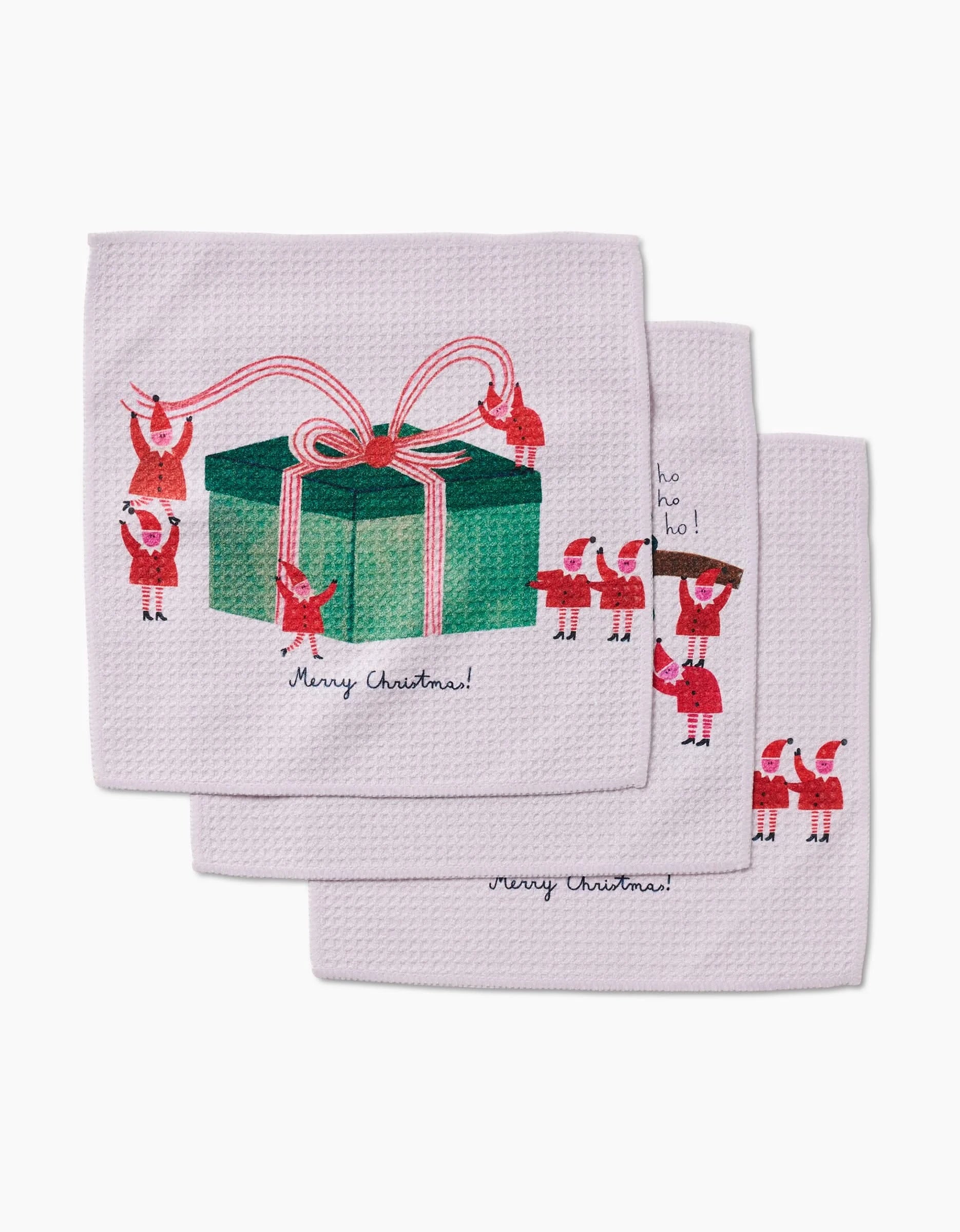 The Little Helpers dishcloth set by Daria Solak features three white Geoweave cloths with small Santas carrying a green gift with a pink ribbon and Merry Christmas! underneath, offering extra absorbency.