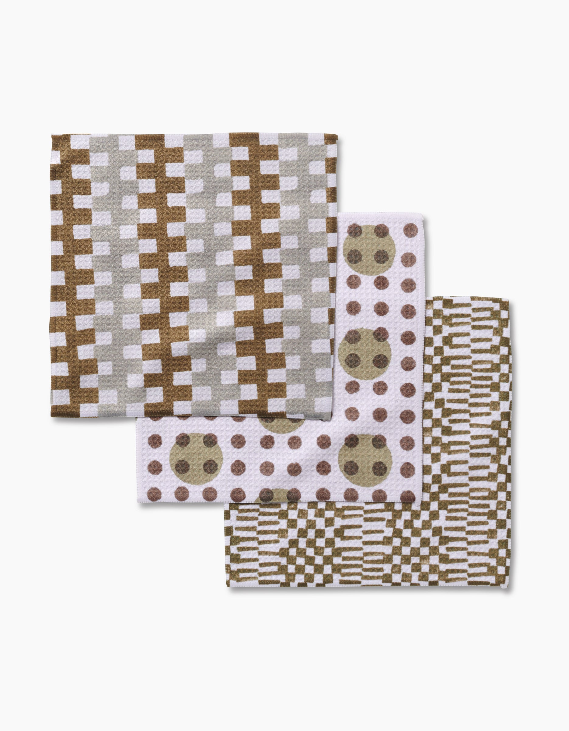 Three folded Lotty dishcloths by Studio Jeannot: top has brown and gray intersecting lines, middle features white with circular and dot patterns, bottom shows a dense brown and white grid—all crafted from premium Geoweave fabric.