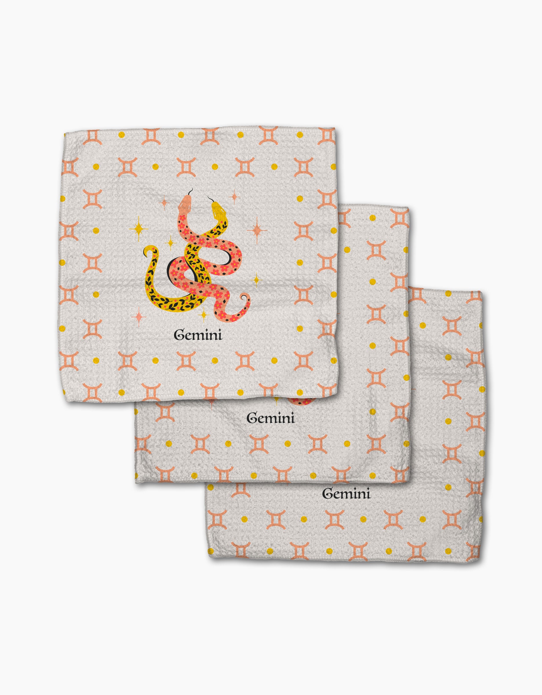 The Lucky Gemini kitchen towel set by Heather Zhou includes three white recycled dishcloths with orange Gemini zodiac symbols, yellow dots, and a colorful snake. Each towel features "Gemini," adding personality to any table.