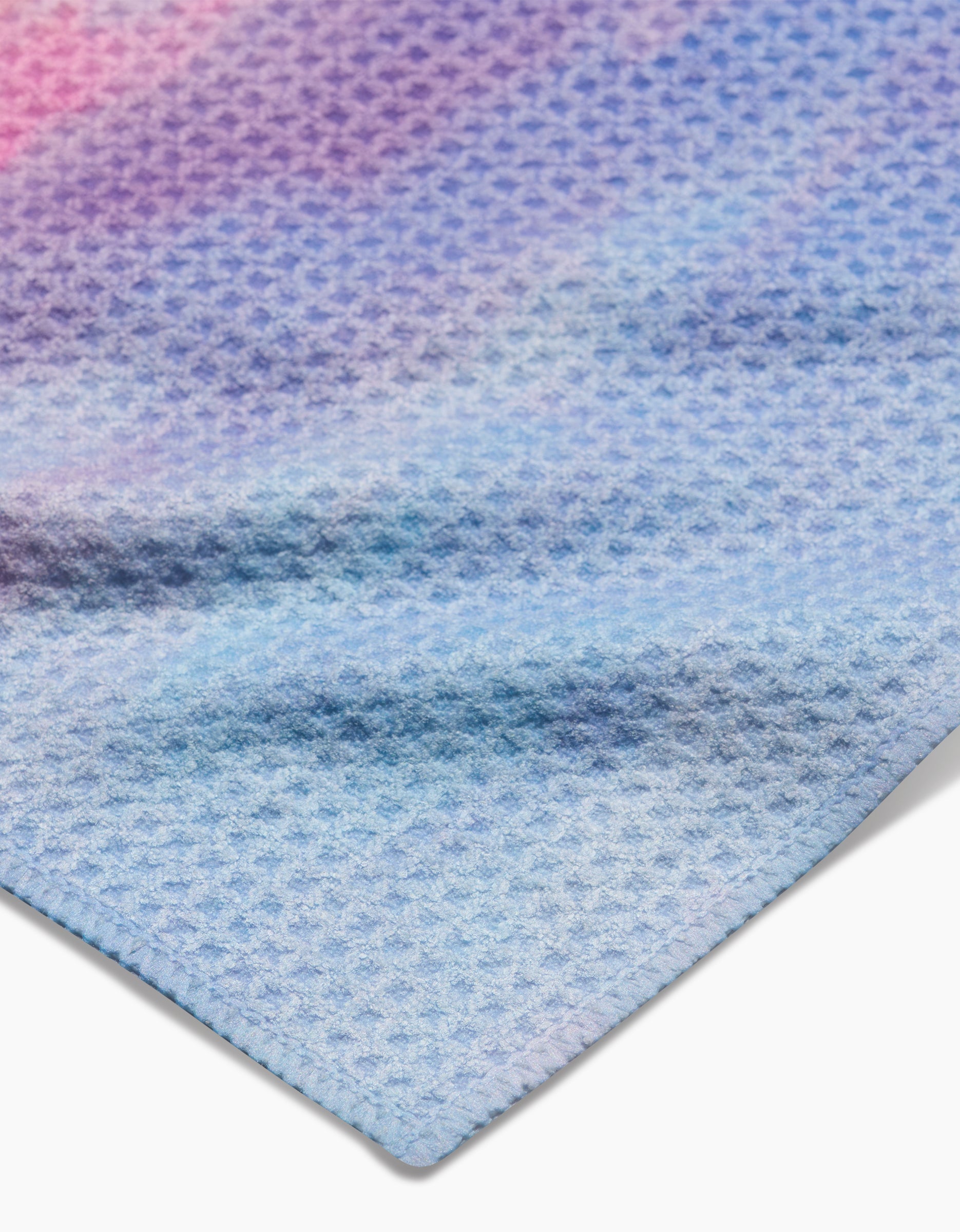 A close-up of the Stefanie Bales Magic In The Sky Geoweave dishcloth showcases its pastel blue, purple, and pink honeycomb pattern with neatly finished edges.