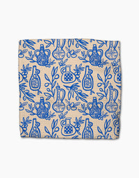 The Mediterranean Pour dishcloth set by Lisa Nelson is beige, made from recycled materials, and features a super-absorbent cloth adorned with a blue pattern of decorative bottles, leaves, and branches covering the entire surface.