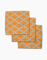 Three Mustard Ogee cloth napkins by Pascale Dilger, featuring a repeating light blue and white geometric pattern, arranged in an overlapping stack—stylish and eco-friendly, made from recycled materials.
