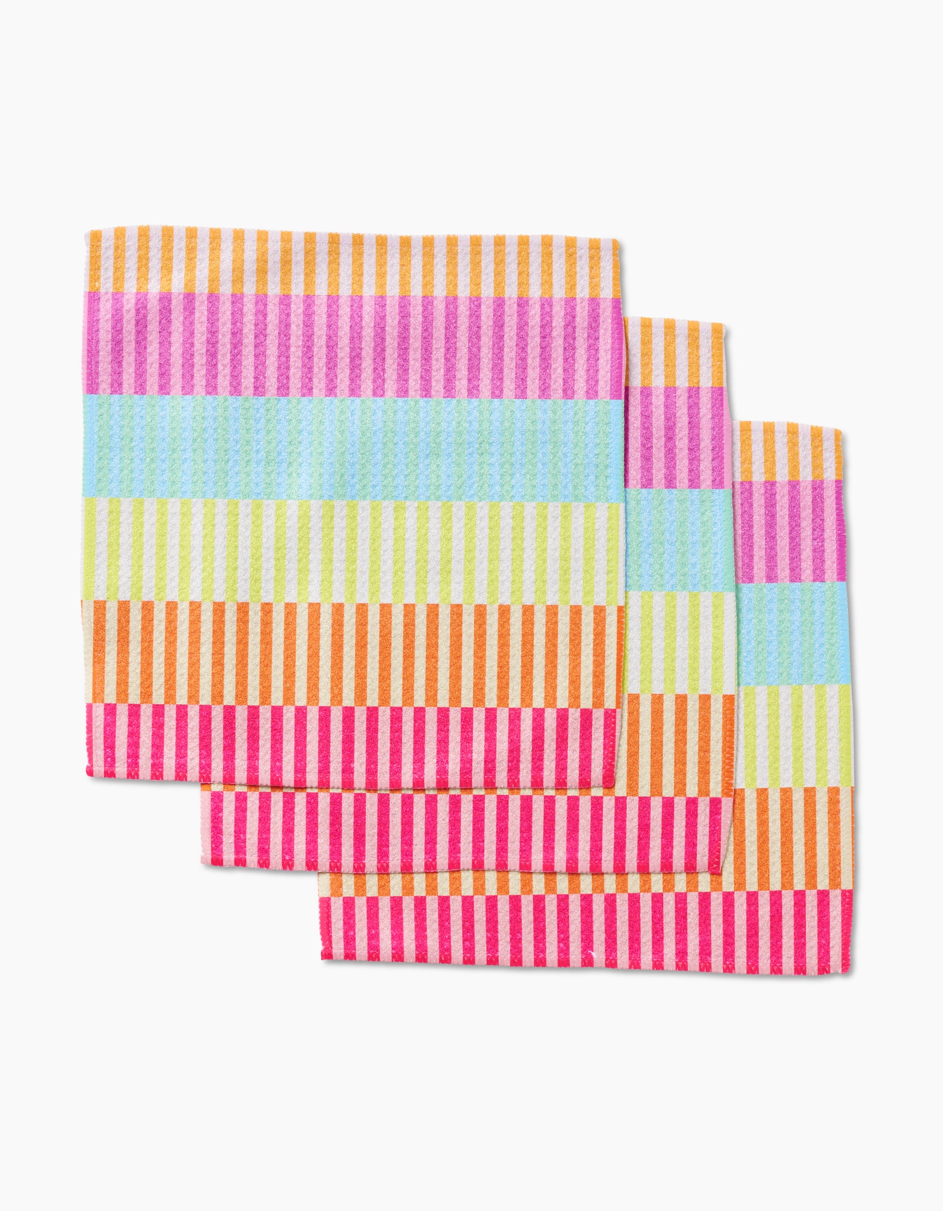 Three GEOMETRY Neon Nights napkins made from Geoweave fabric are stacked diagonally, featuring colorful horizontal and vertical stripes in pink, blue, yellow, orange, and red.