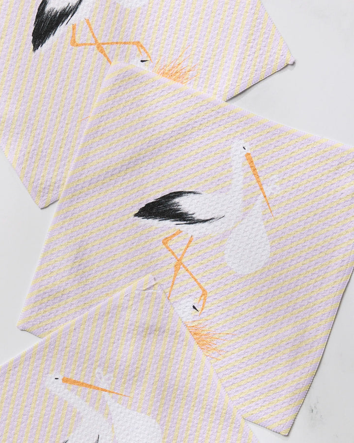 The Geometry New Mom dishcloth set features three white cloths with yellow diagonal stripes and a stork holding a bundle, made from recycled materials for super absorbency, neatly displayed on a white surface.