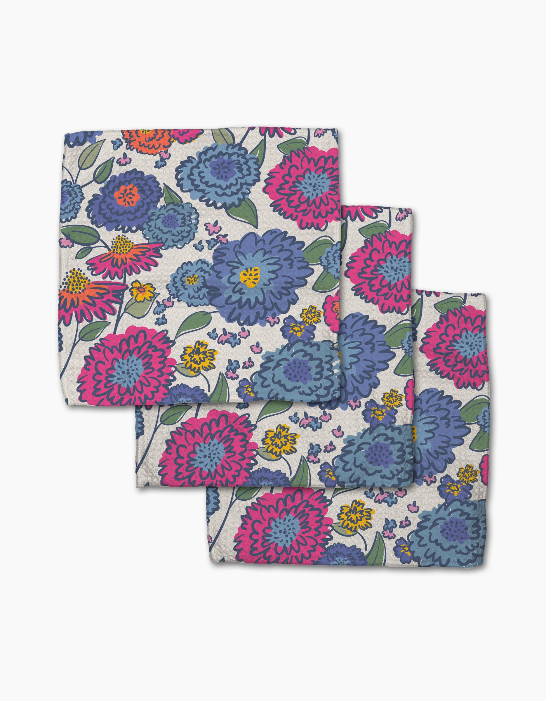 The Painterly Meadow dishcloth set by Kris Ruff includes three colorful cloth napkins made from recycled materials, featuring bold blue, pink, and purple flowers with green leaves on a light background.