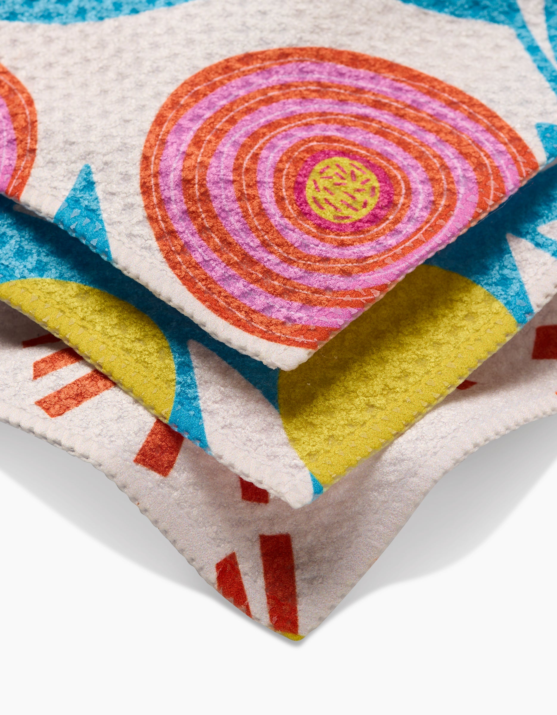 A close-up of Parade by Lizzie Clark shows its vibrant Geoweave fabric—bold geometric patterns in pink, orange, yellow, blue, and red—ideal for durable and colorful dishcloths.