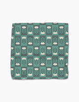 The Park Lane dishcloth by Charlie Rowan Designs is green with a grid of white flowers, stems, and leaves on a darker green background. Made from super-absorbent Geoweave fabric for efficient cleaning.