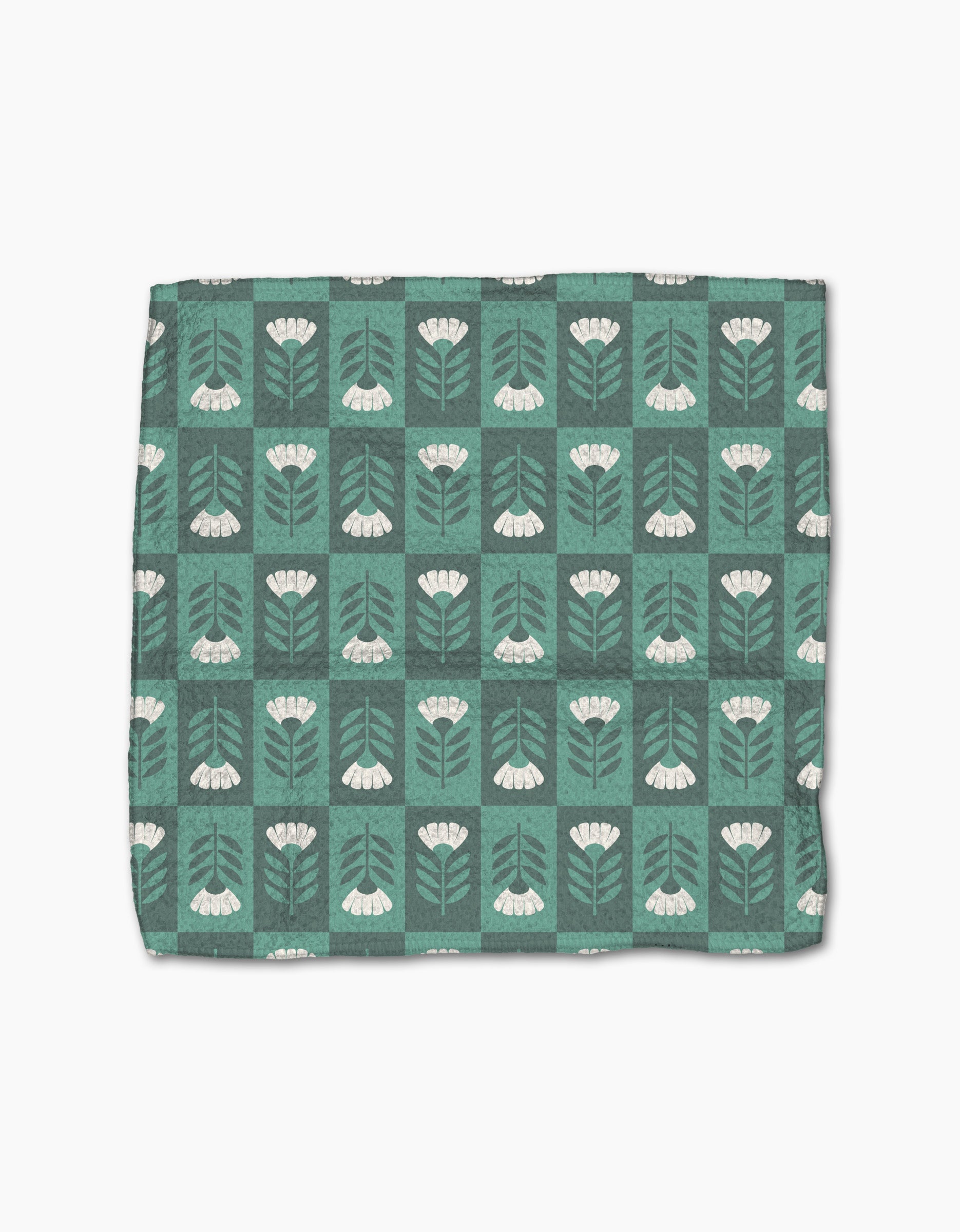 The Park Lane dishcloth by Charlie Rowan Designs is green with a grid of white flowers, stems, and leaves on a darker green background. Made from super-absorbent Geoweave fabric for efficient cleaning.