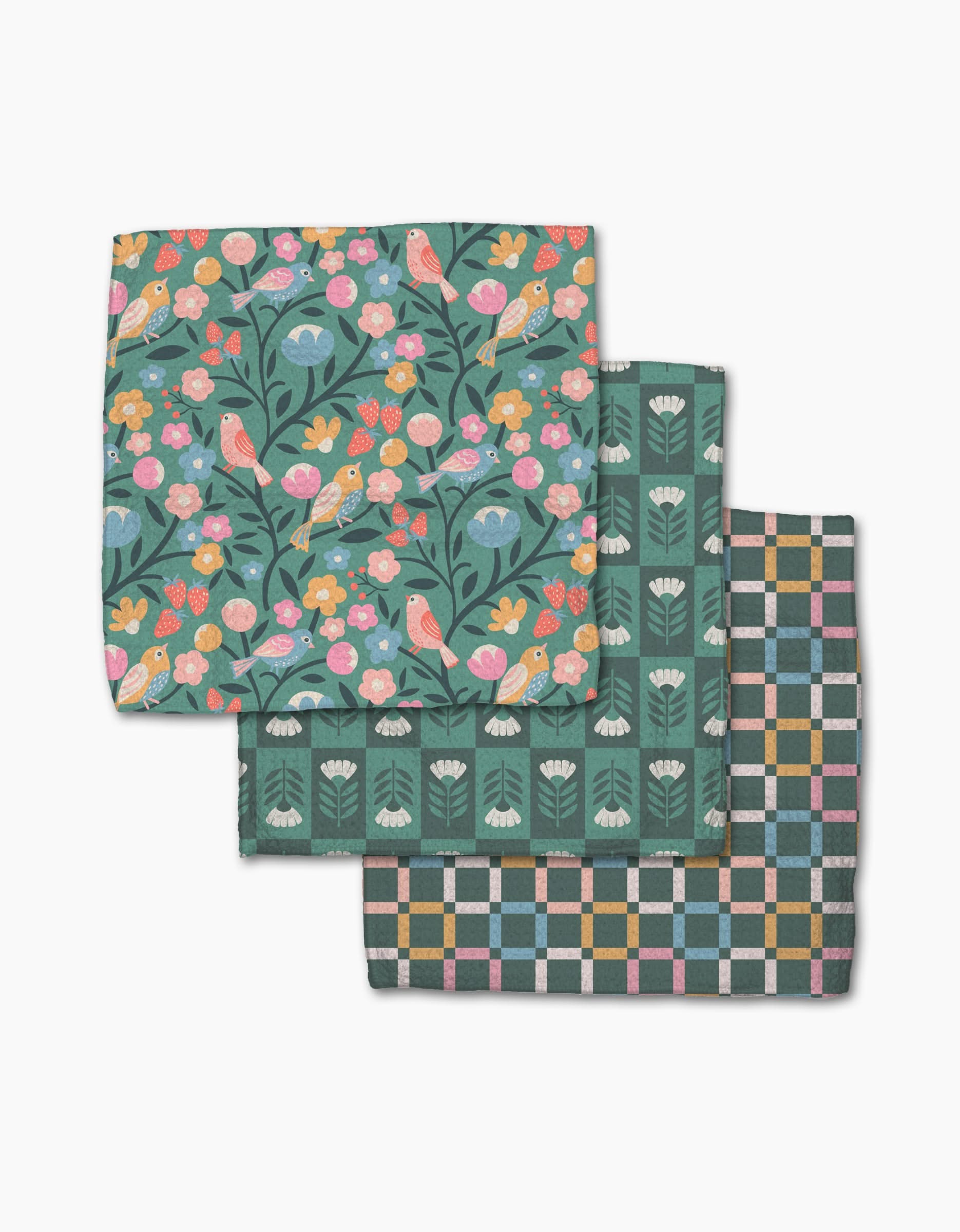 Three folded Park Lane cloth napkins by Charlie Rowan Designs, made from super-absorbent Geoweave: top shows colorful birds and flowers on dark, middle is green with white floral motifs, bottom has a pastel geometric checkered design.