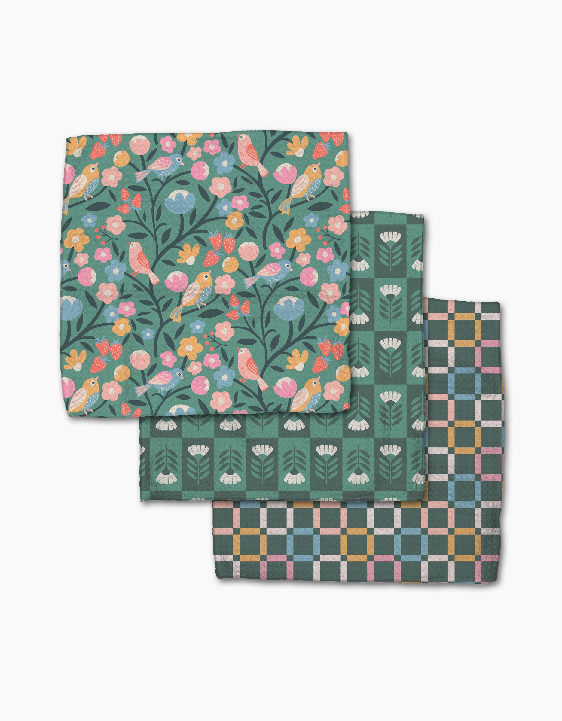 Three folded Park Lane cloth napkins by Charlie Rowan Designs, made from super-absorbent Geoweave: top shows colorful birds and flowers on dark, middle is green with white floral motifs, bottom has a pastel geometric checkered design.