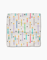 The Party Pop dishcloth by Vaishali Design Studio features a white textured Geoweave fabric with vibrant birthday candles, black stars, and yellow flames. Eco-friendly and durable, its perfect for adding a festive touch to your kitchen.