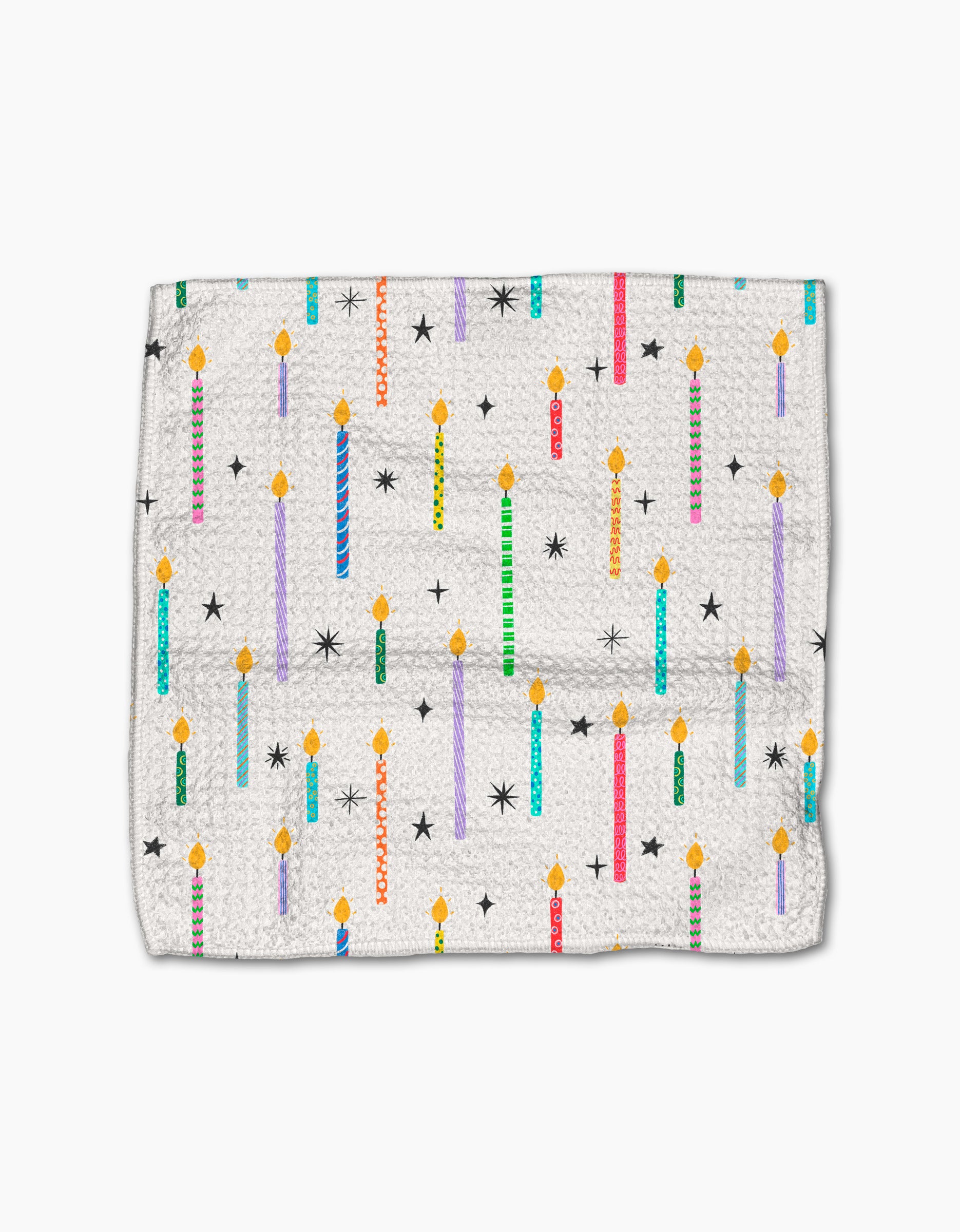 The Party Pop dishcloth by Vaishali Design Studio features a white textured Geoweave fabric with vibrant birthday candles, black stars, and yellow flames. Eco-friendly and durable, its perfect for adding a festive touch to your kitchen.