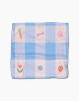 The Pawfect Picnic dishcloth set by Letters By Shells features blue and white checks with small carrot, bone, paw print, flower, blueberry, and strawberry illustrations. Made from recycled materials; shown on a plain white background.