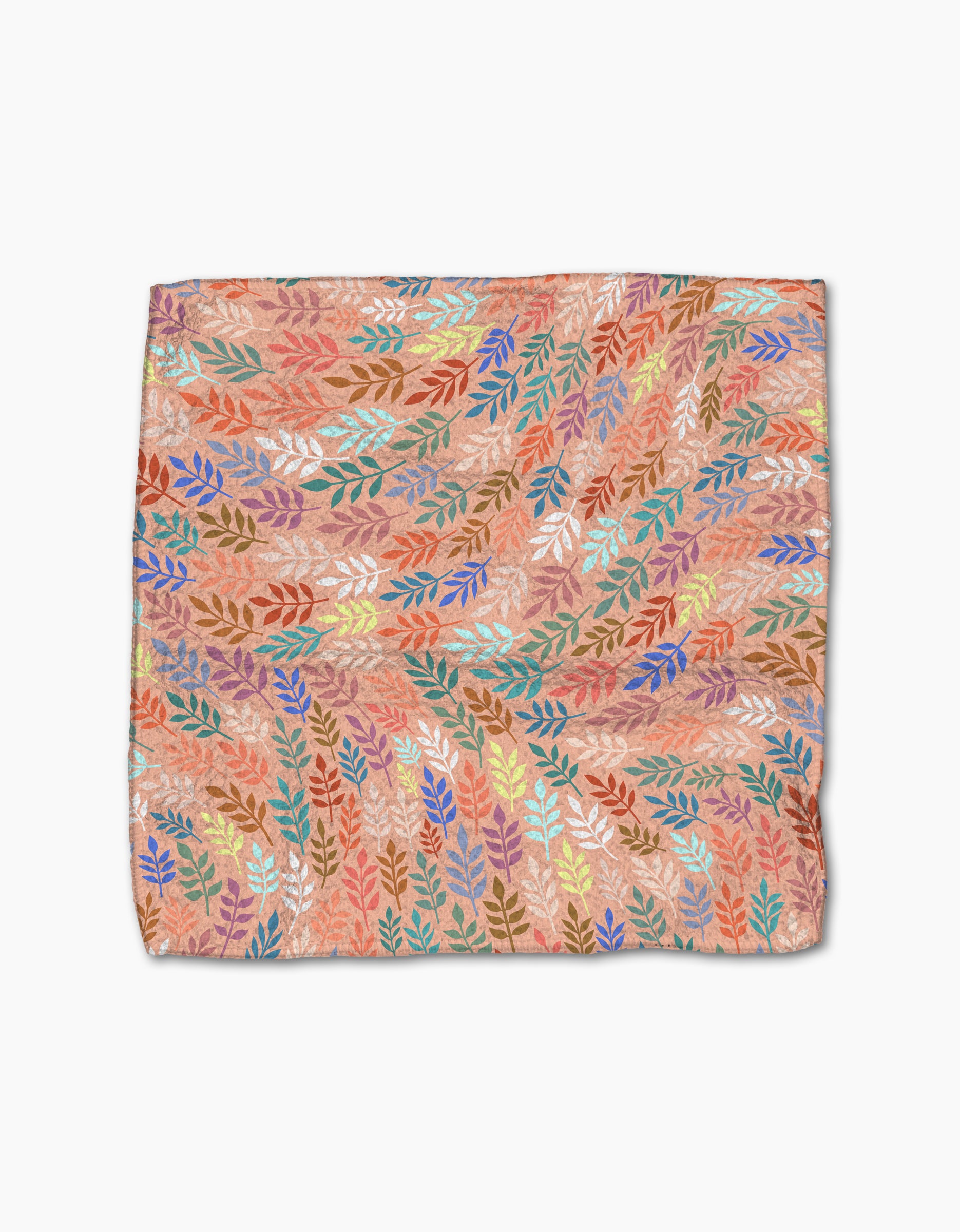 The Rachel Parker Peachy Leaf Swirl set features square dishcloths with a colorful leaf pattern—blue, orange, yellow, red, and green—on a peach background. Made from recycled materials with a soft, slightly wrinkled feel.