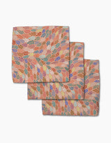 Three folded Peachy Leaf Swirl napkins from Rachel Parker, featuring a multicolored leaf pattern on peach, are stacked on white—a stylish and eco-friendly addition to any dishcloth set.