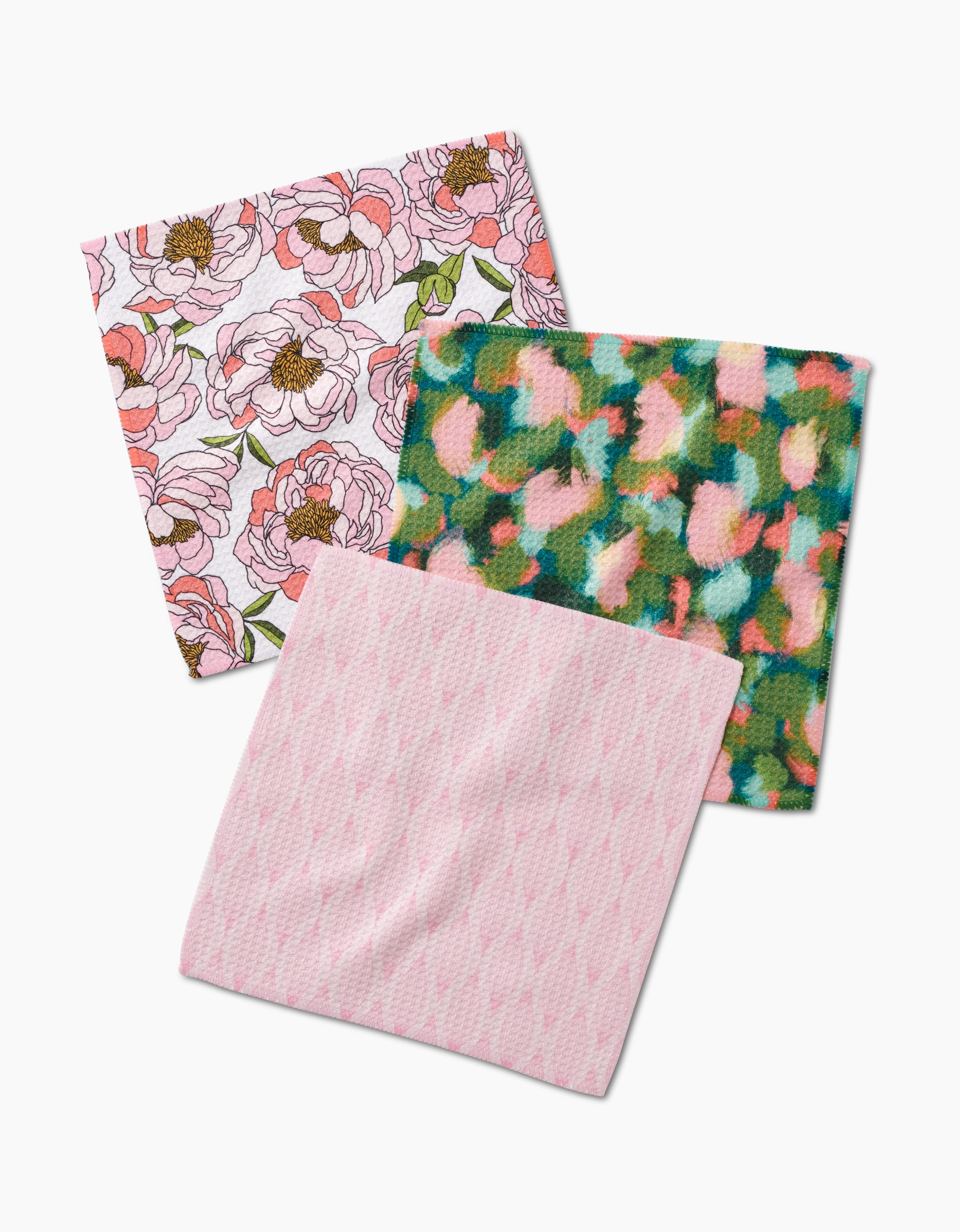 Shelley Smiths Peony Paradise set: three square dishcloths crafted from recycled Geoweave fabric—one with pink flowers and green leaves, one with an abstract multicolored design, and one in light pink geometric patterns on white.