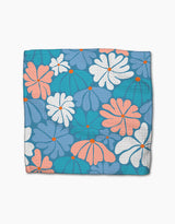 Picnic Flowers by Rachel Parker: a square blue dishcloth with a vibrant floral pattern of large white, pink, and orange flowers plus orange dots on textured teal, made from super-absorbent recycled materials.