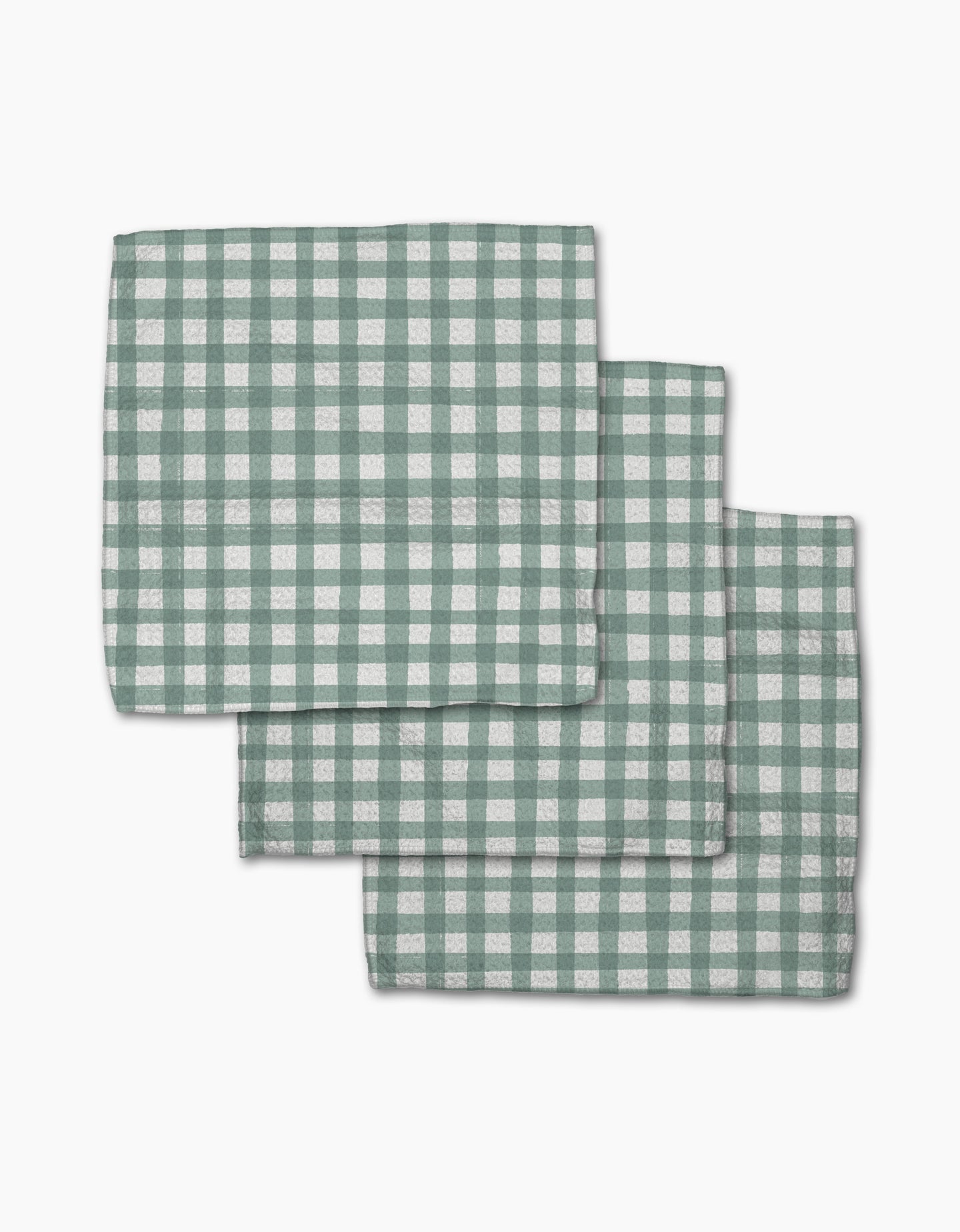Three Picnic Gingham napkins from Hufton Studio, featuring a green and white check pattern, are neatly stacked with slight overlap on a white background.