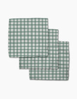 Three Picnic Gingham napkins from Hufton Studio, featuring a green and white check pattern, are neatly stacked with slight overlap on a white background.